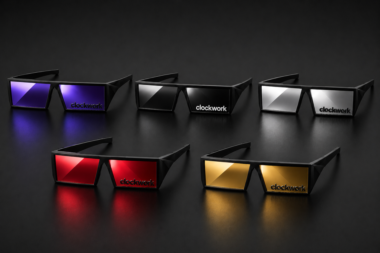 Five pairs of black sunglasses with rectangular frames and colored reflective lenses, each labeled with the word 'clockwork' in black, arranged on a dark surface with a dark background. The lenses are in purple, black, white, red, and yellow colors.