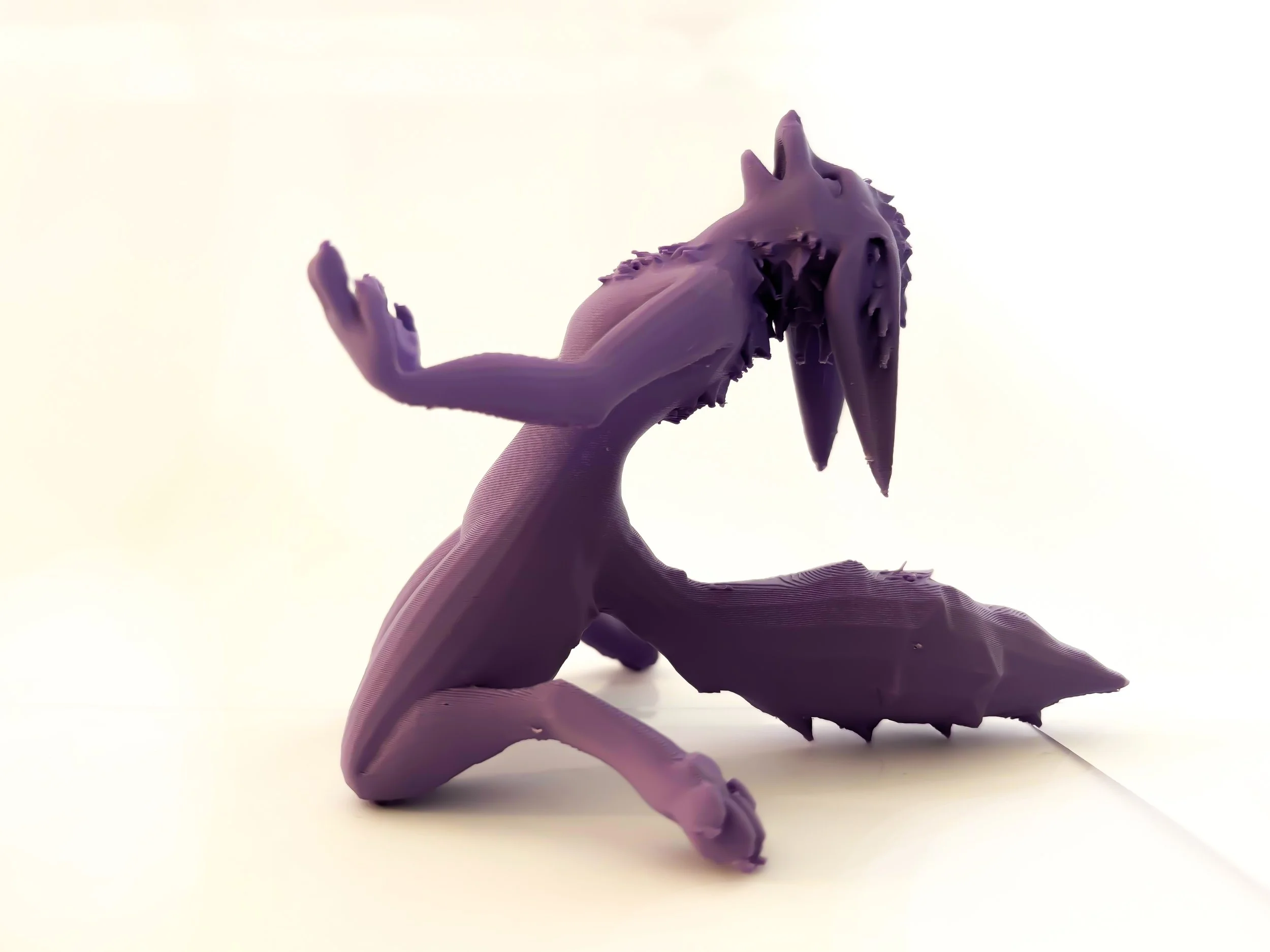 3D-Printed purple furry , sitting on a plain white surface with a light background.