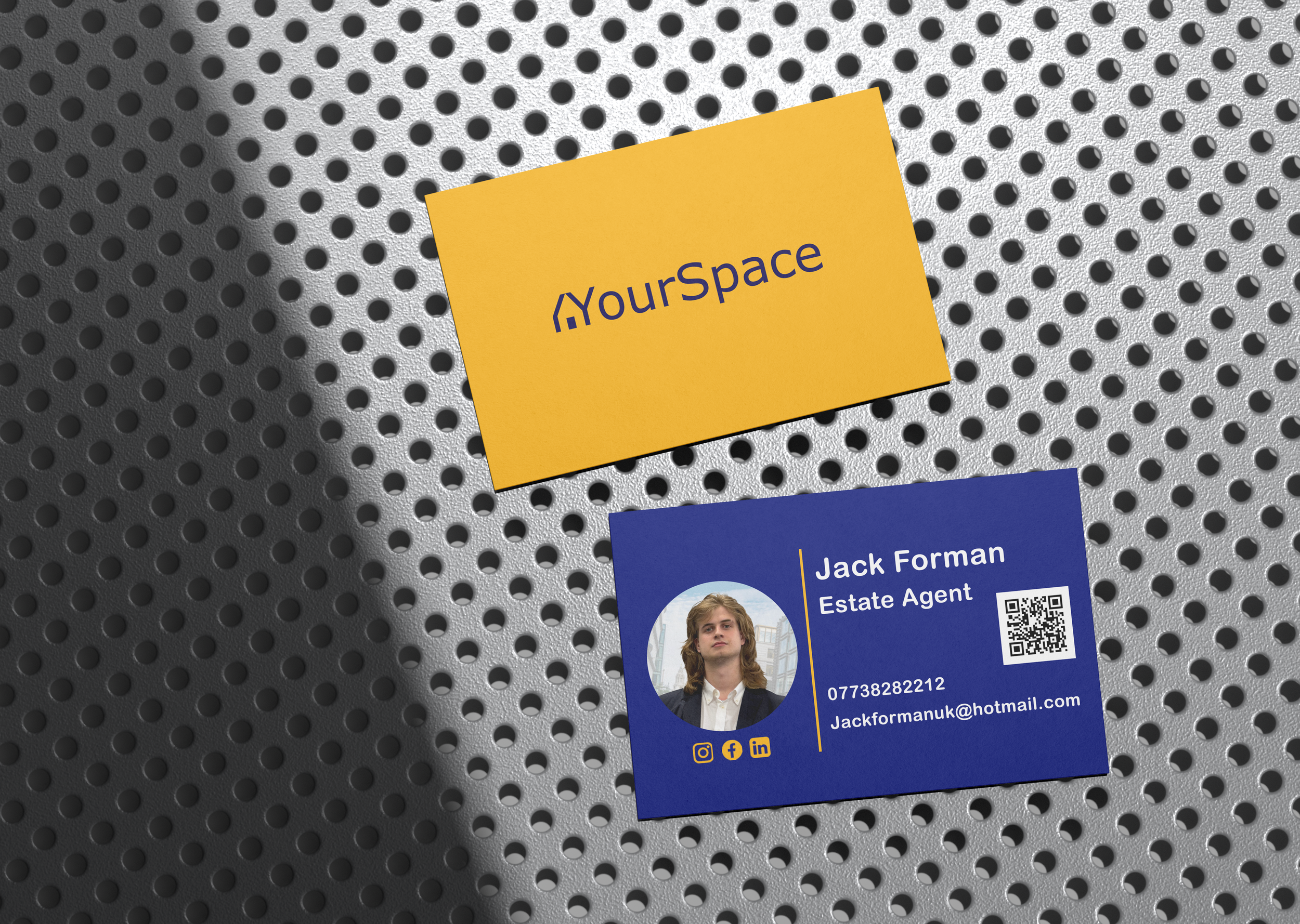 Close-up of a yellow and blue business cards placed on a perforated metallic surface. One card displays the logo 'YourSpace,' and the other shows the name 'Jack Forman,' with contact details including a phone number, email, and icons for social media