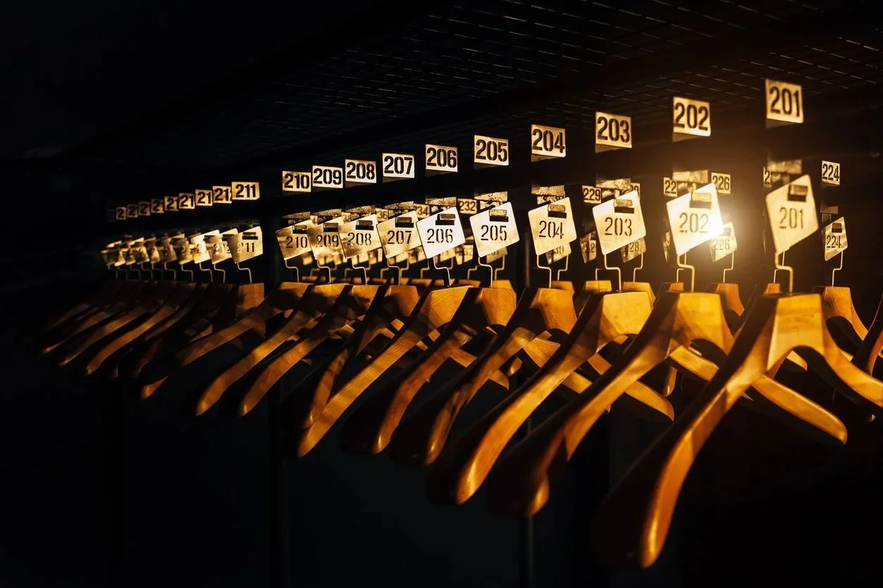 wooden hangers with numbers in a dark cloakroom