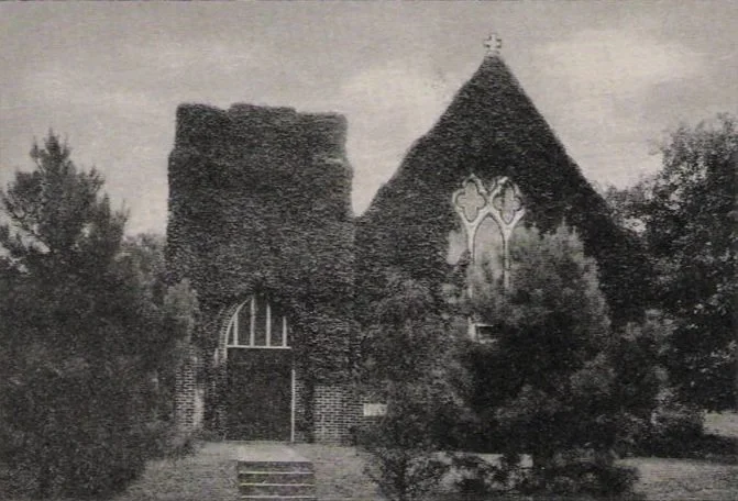 Black and white photo of an old, partially ruined brick church with trees surrounding it.