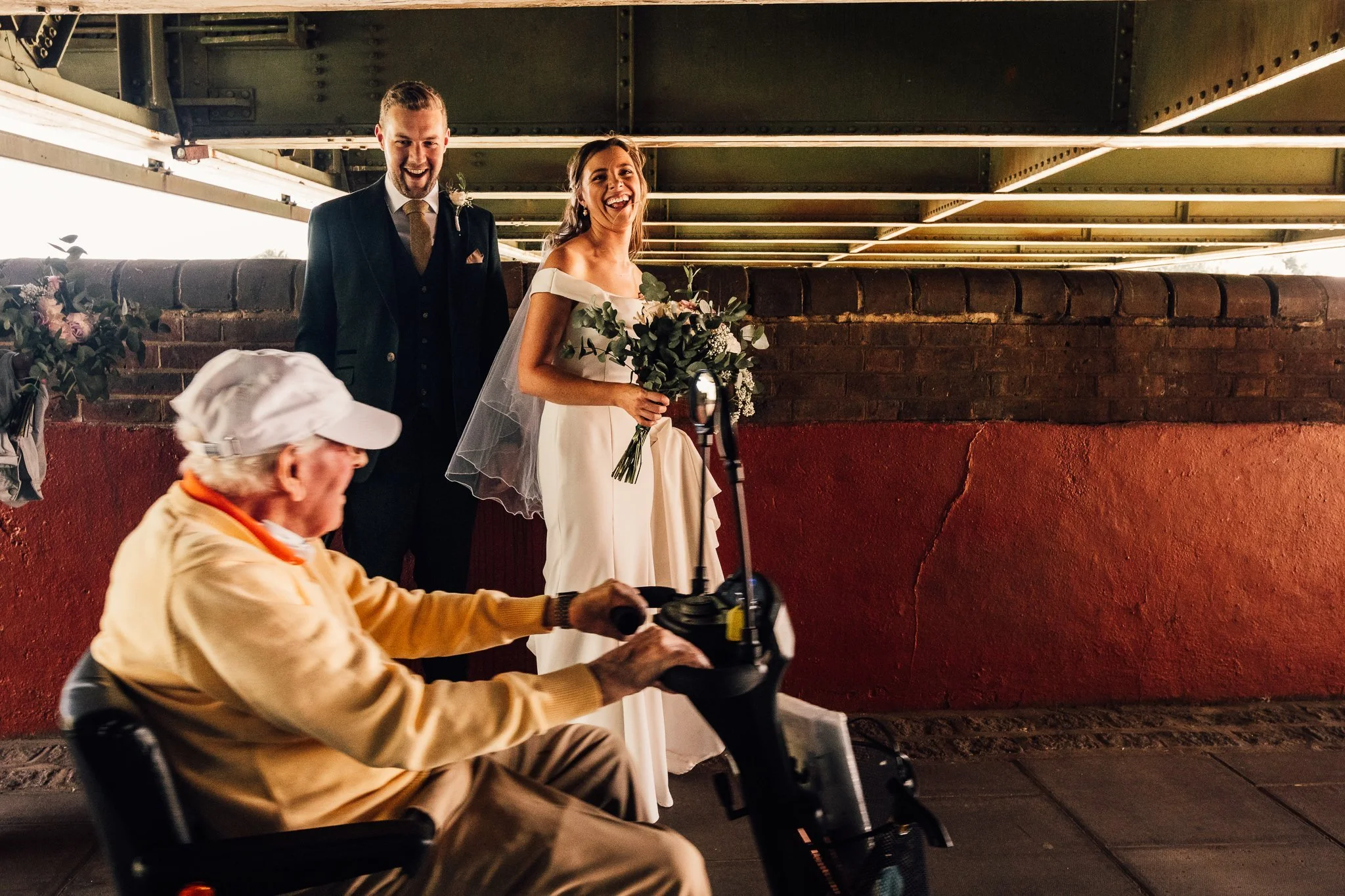  Bride and Groom laughing under Hammersmith bridge 