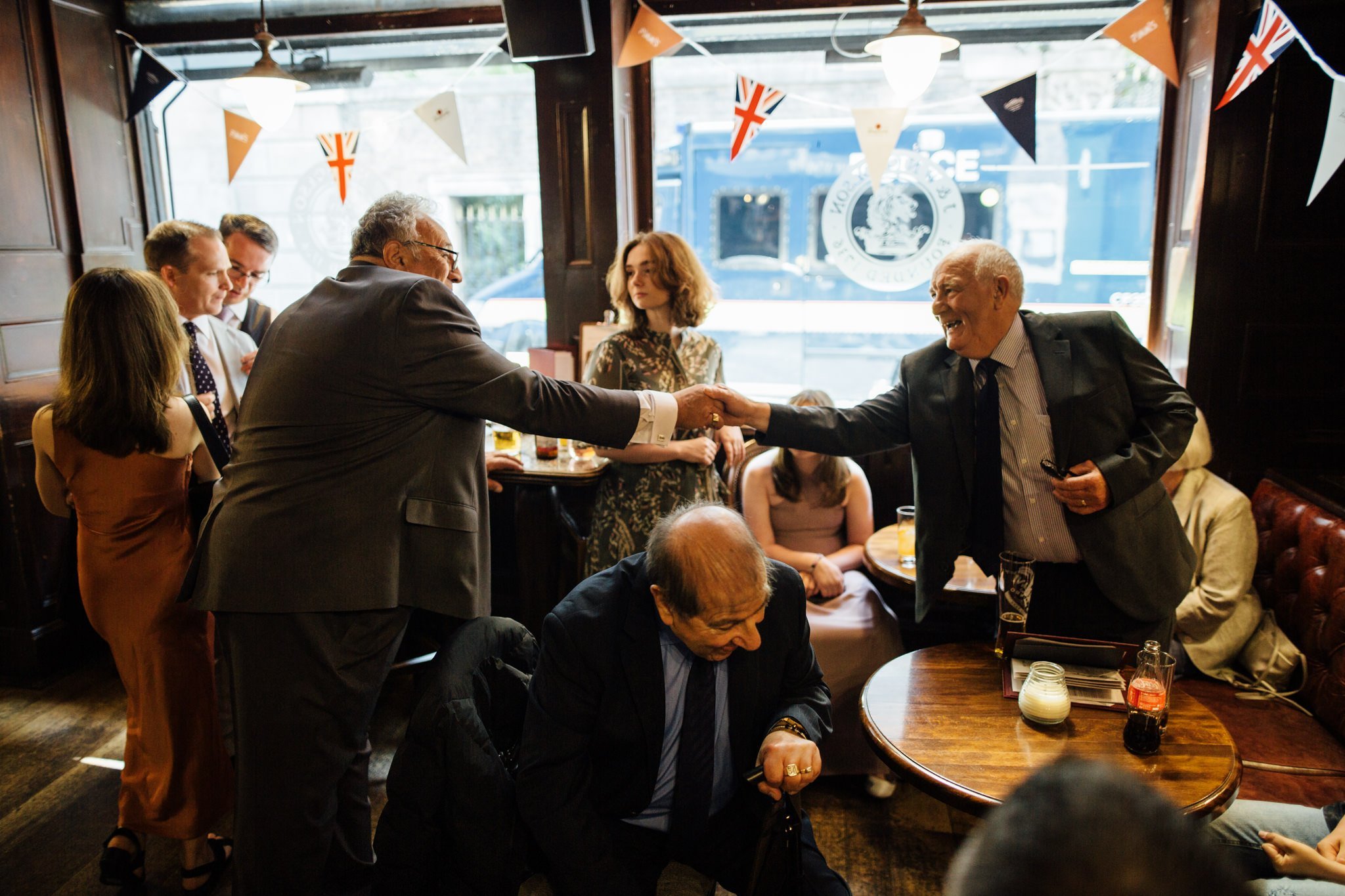  Two older wedding guests shaking hands 