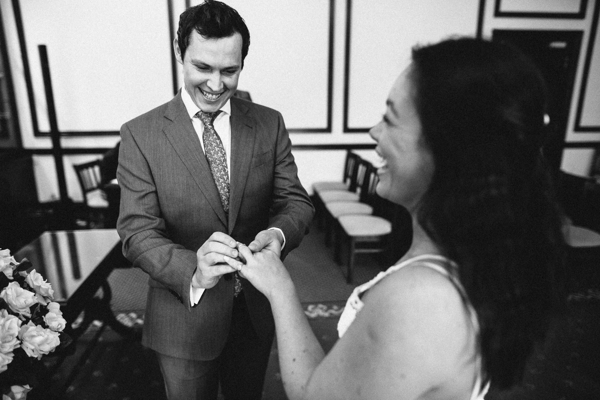  Groom puts a ring on the finger of the Bride during the ceremony at The Mansion 