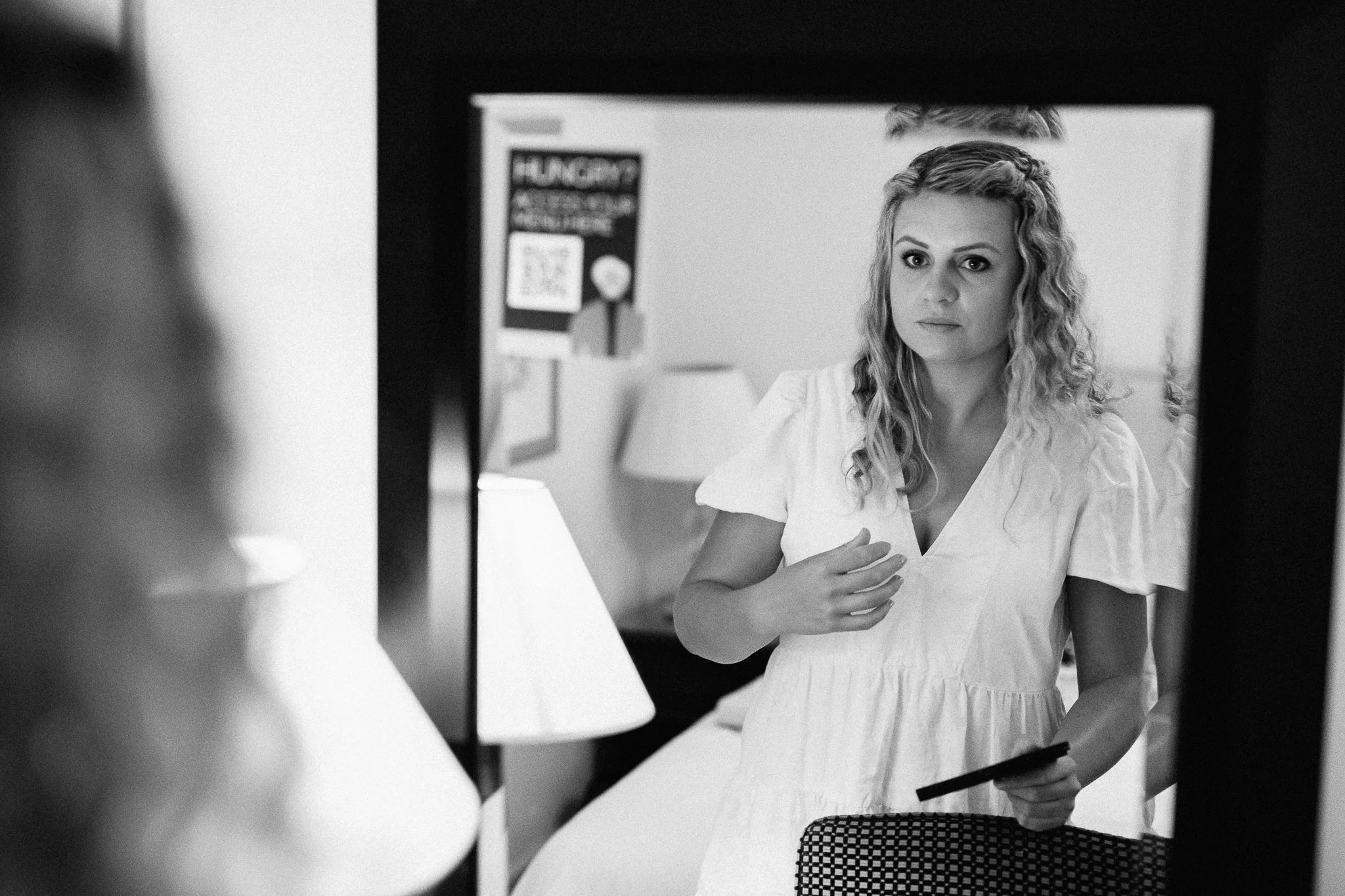  Bride looks at her reflection in the mirror as she gets ready for the ceremony at Leatherhead Register Office 