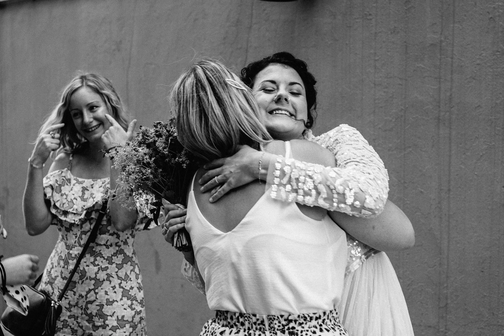  Bride hugging her friend outside of Hammersmith Register Office. 