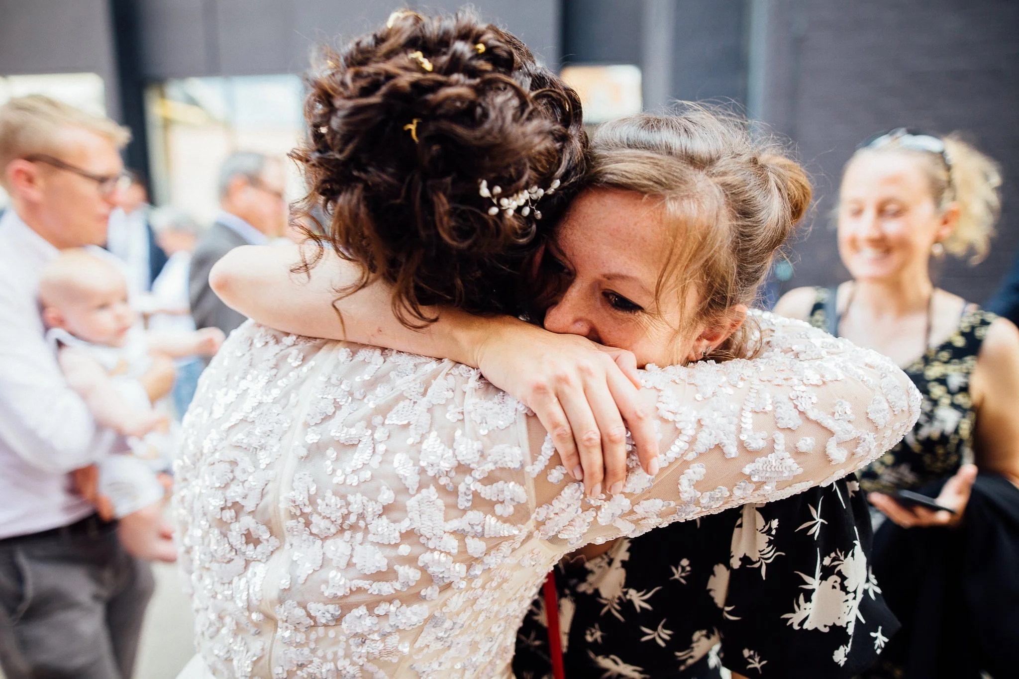  Bride hugs her friend outside Hammersmith Register Office. 