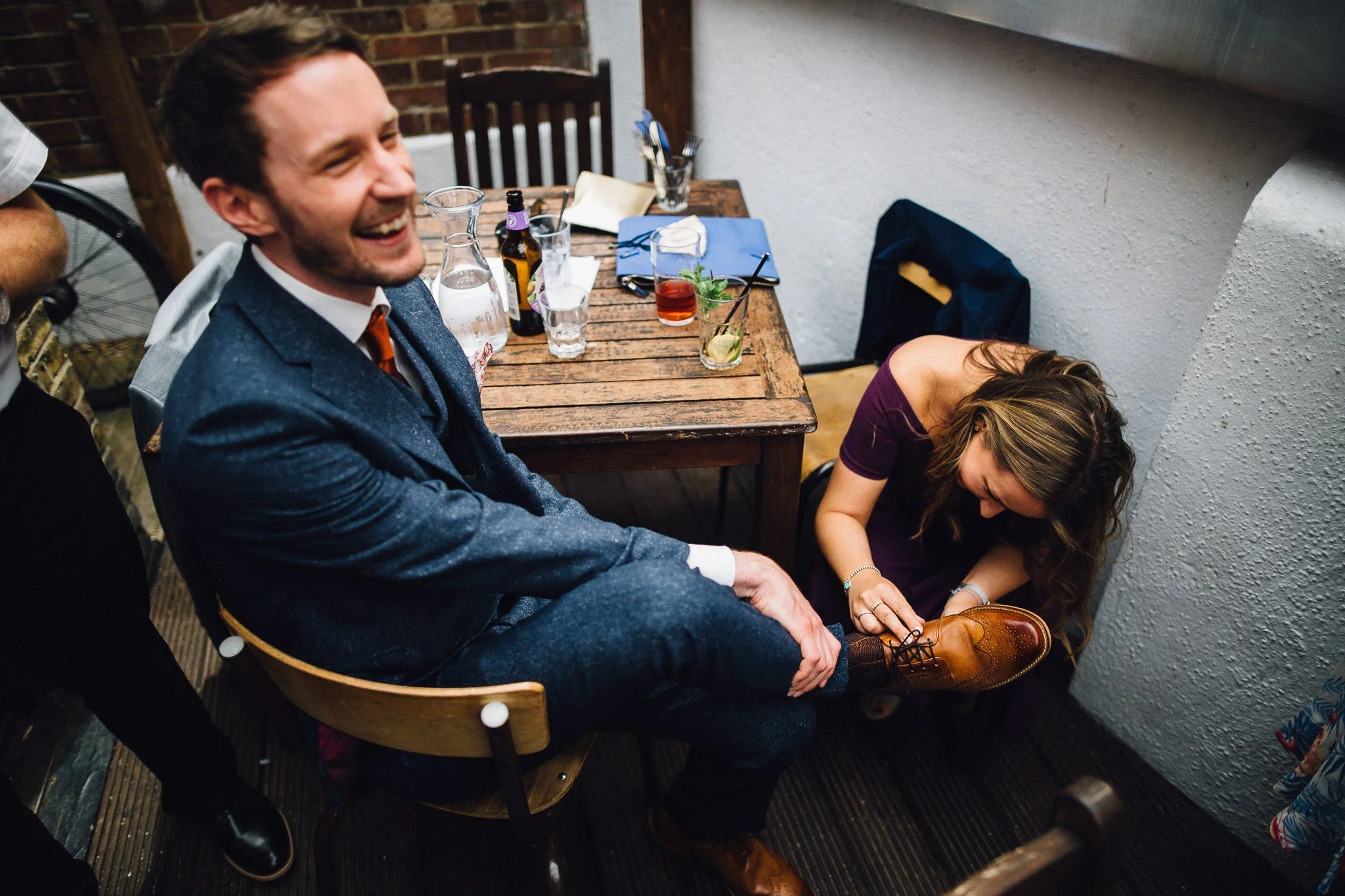  Groom has a sticker taken off his shoe before the wedding at  Islington Town Hall 