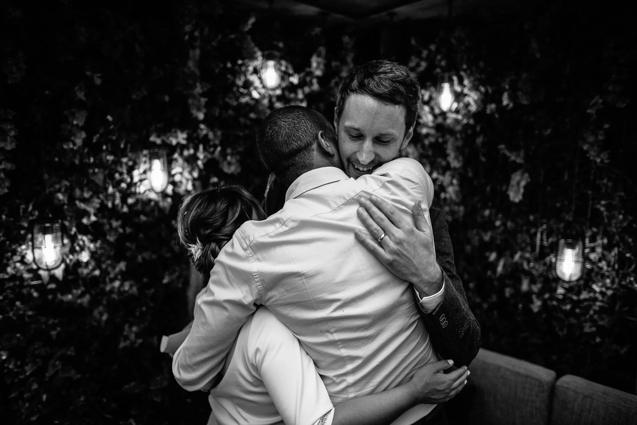  Bride and Groom hug their friend on their wedding day at  Islington Town Hall 
