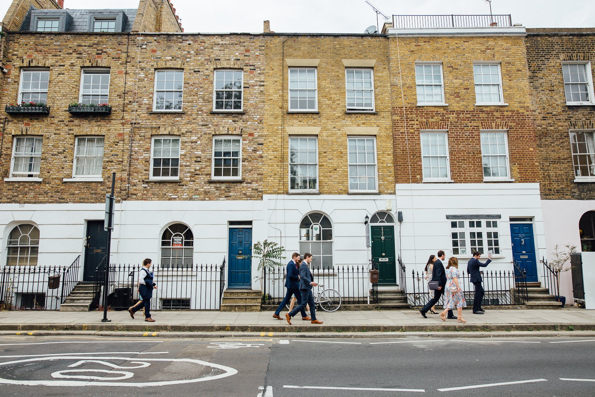  Groom and the wedding guests walking towards  Islington Town Hall 