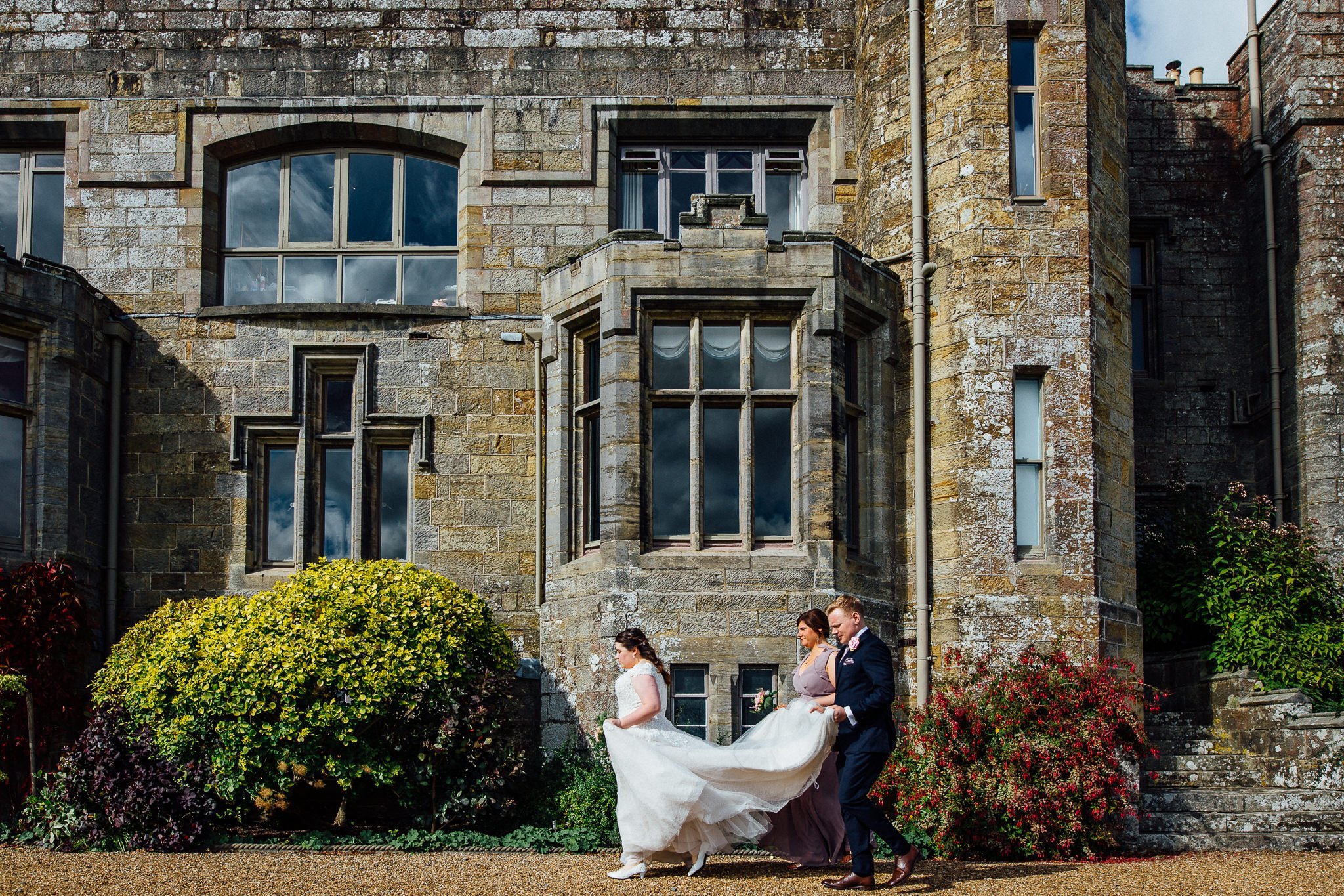  Bride walks to the ceremony at Wadhurst Castle 