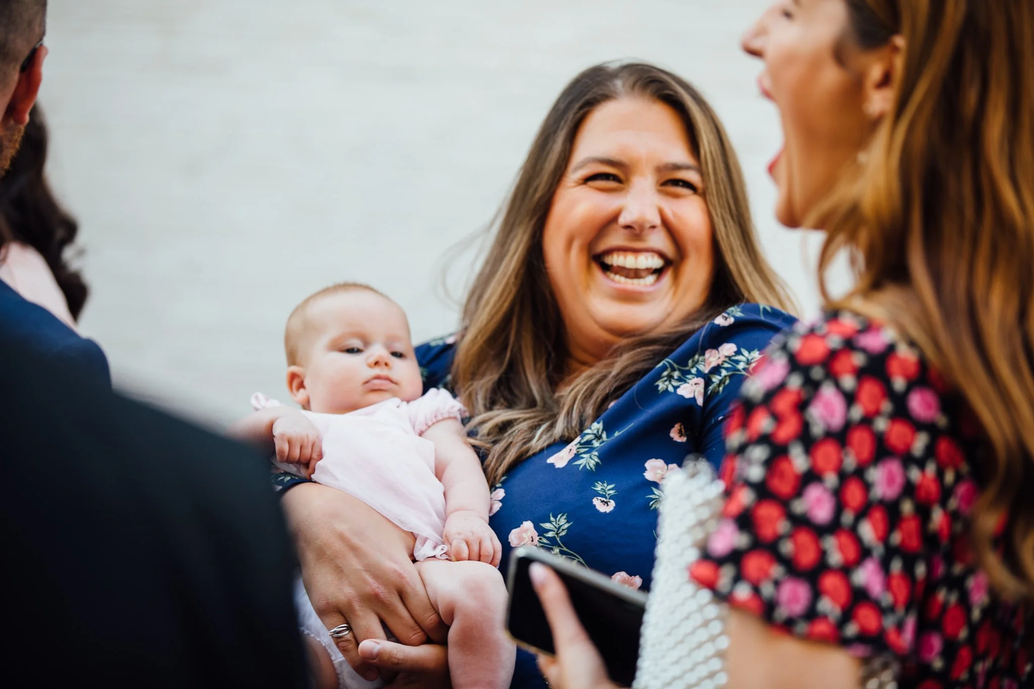  Guest smiling whilst holding a baby. 