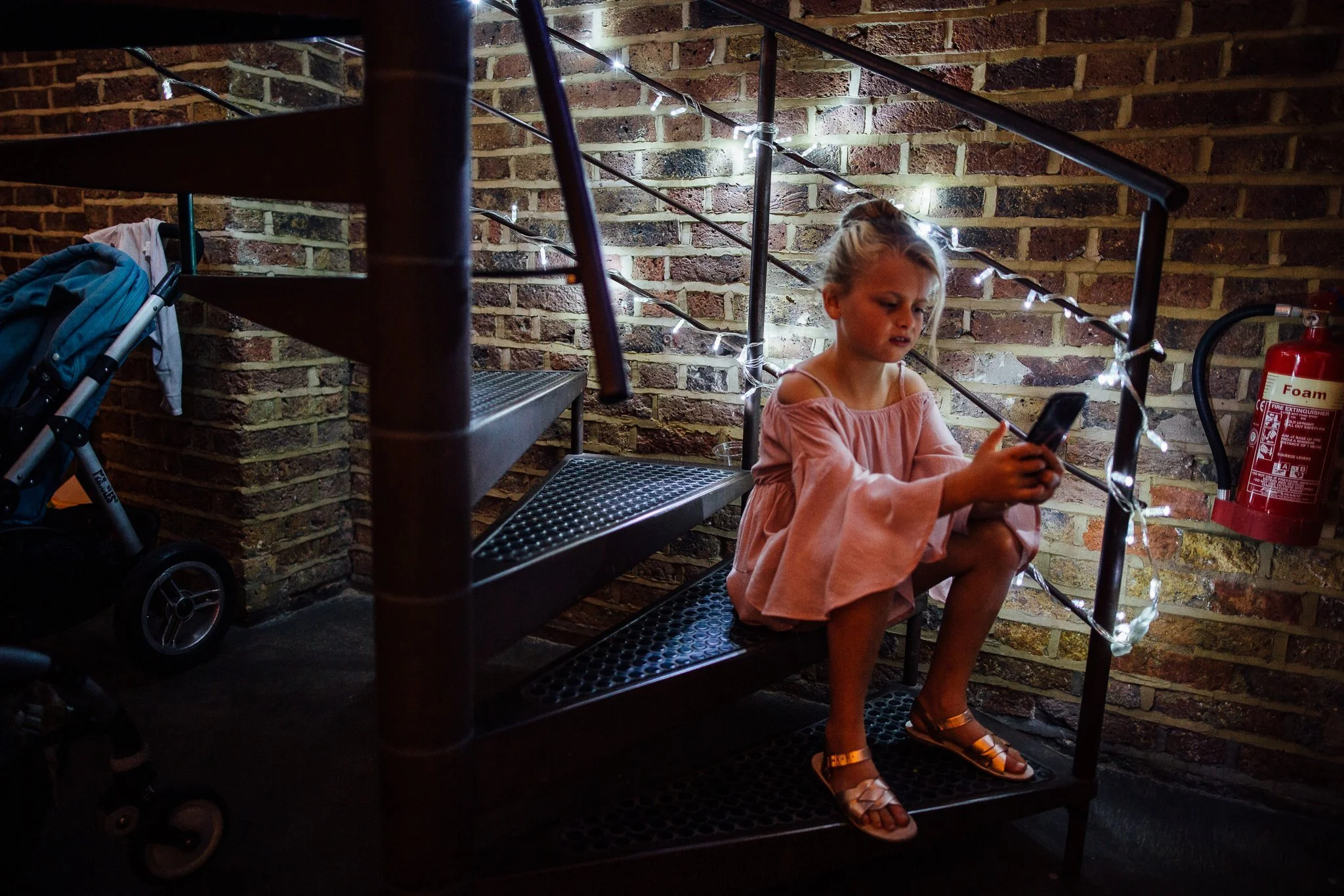  Girl sits on a metal staircase looking at her phone at Shoreditch Studios. 