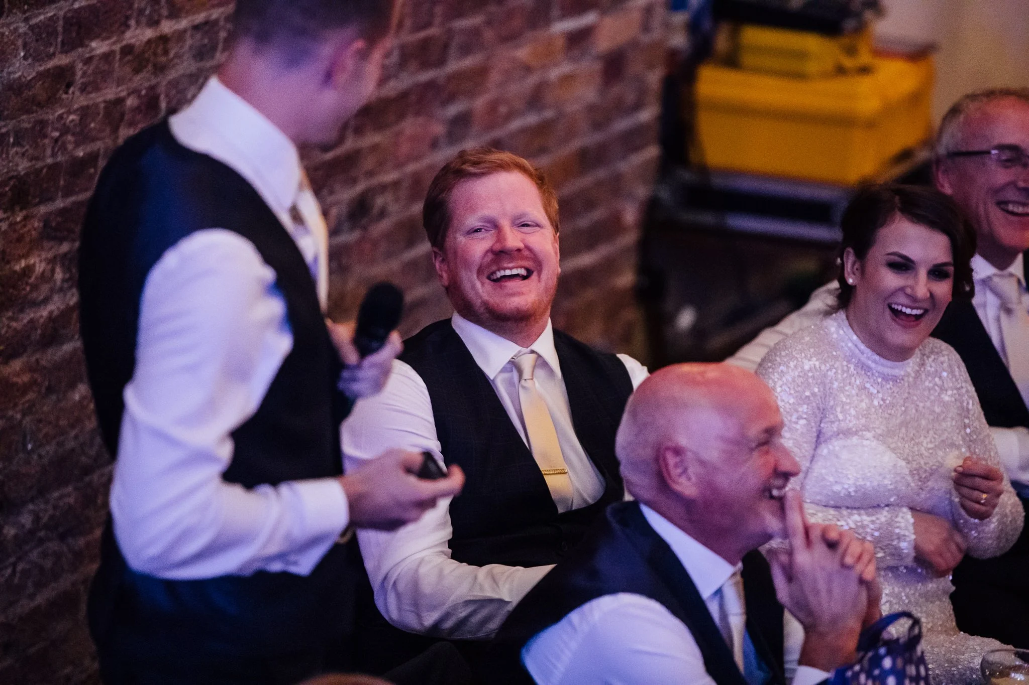  Groom laughs at the best man speech. 