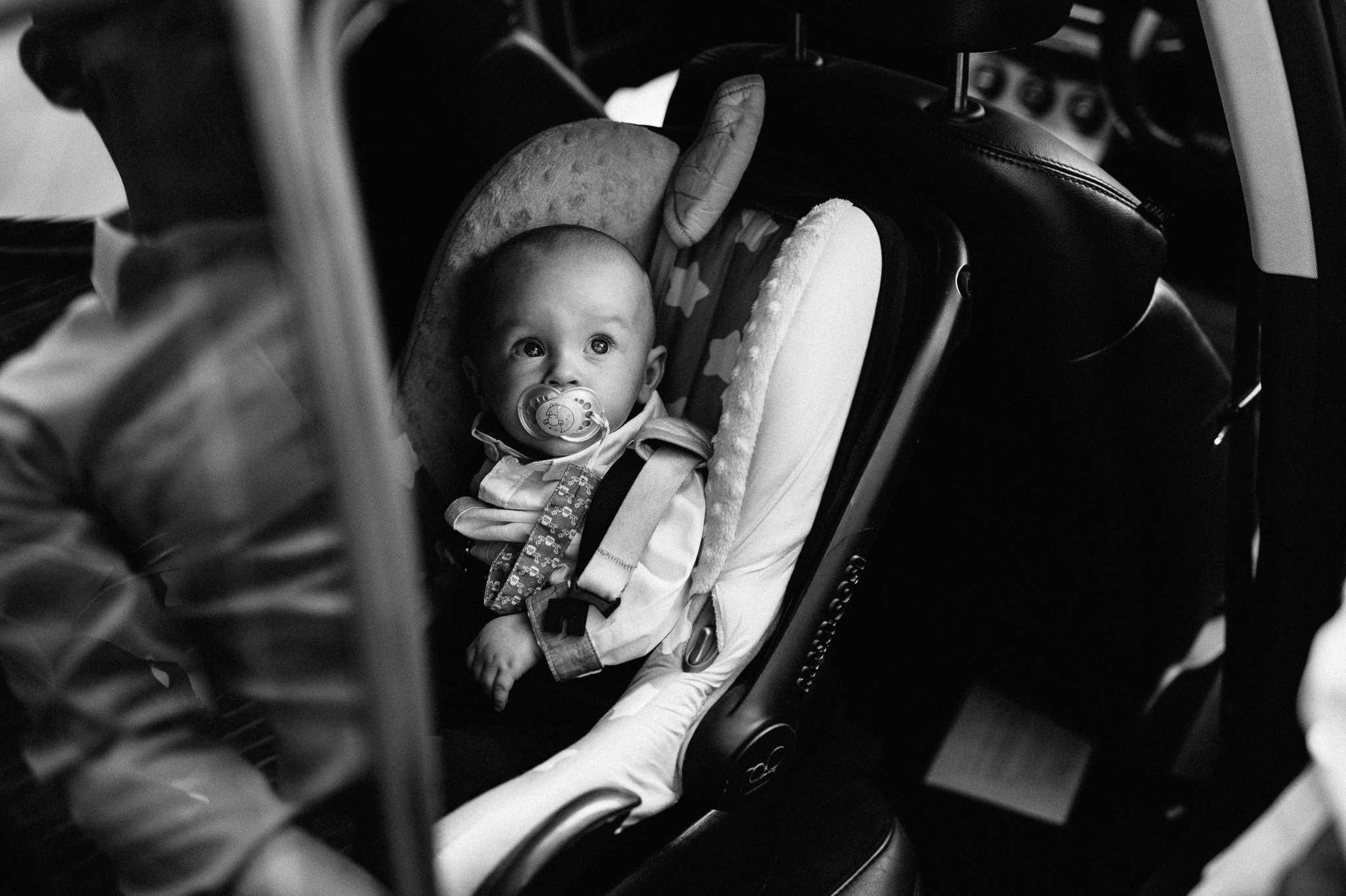  Baby being put in his car seat. 