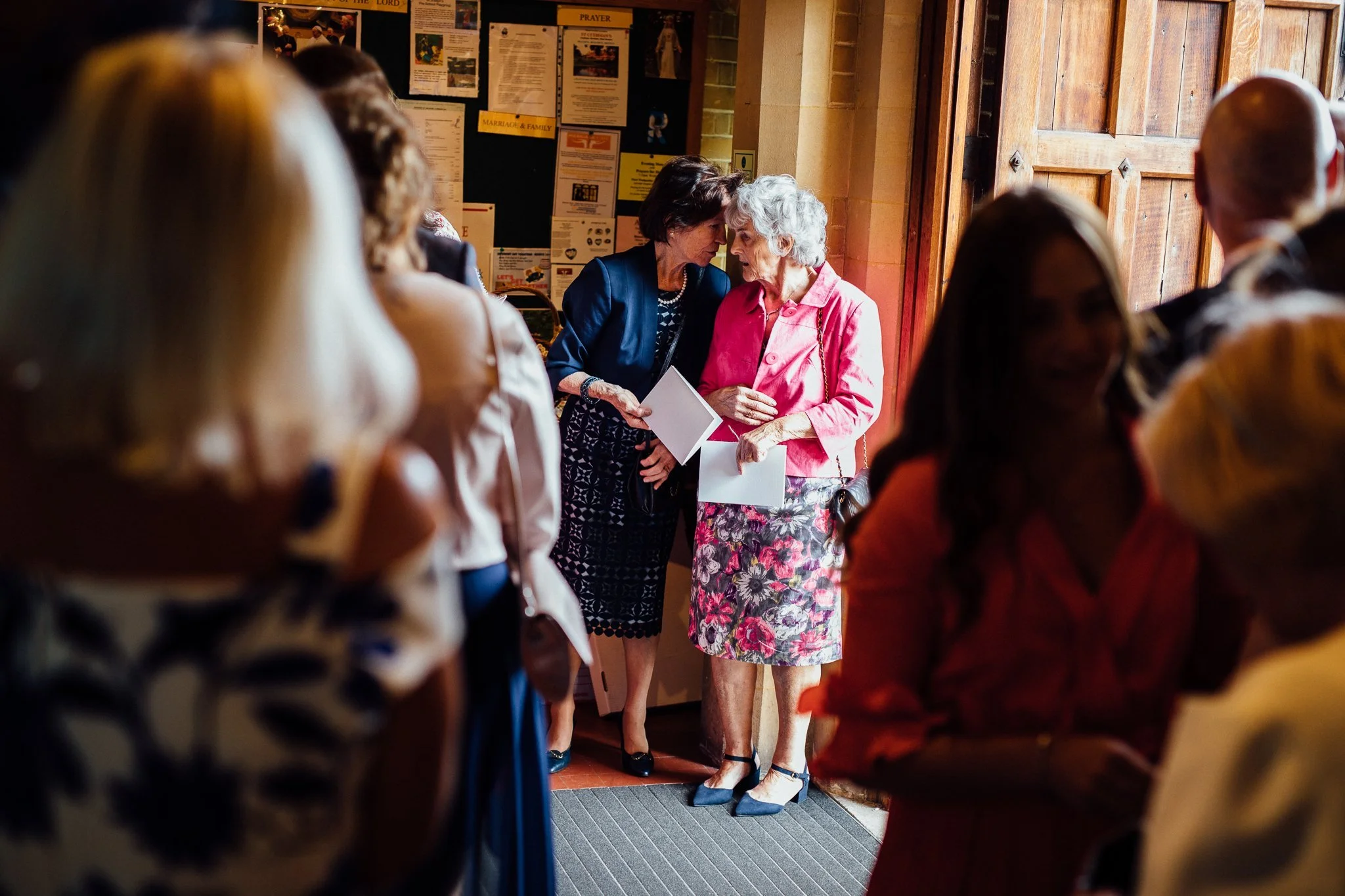  Two wedding guests gossip at The Holy Family Church in Reigate 