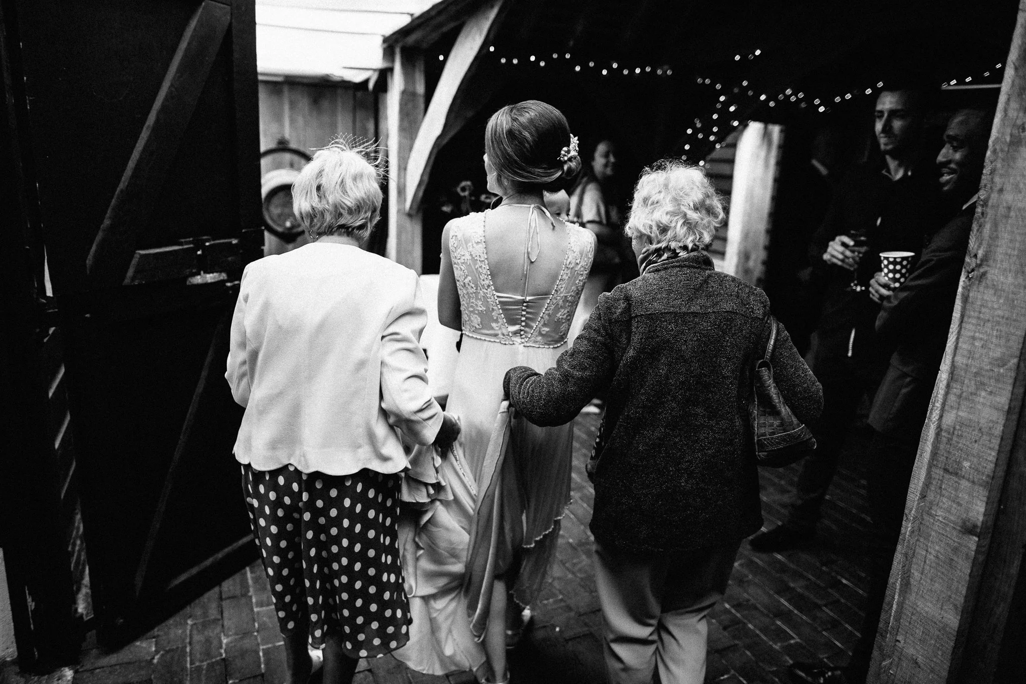  Guests help the Bride into Gildings Barns in Newdigate Surrey 