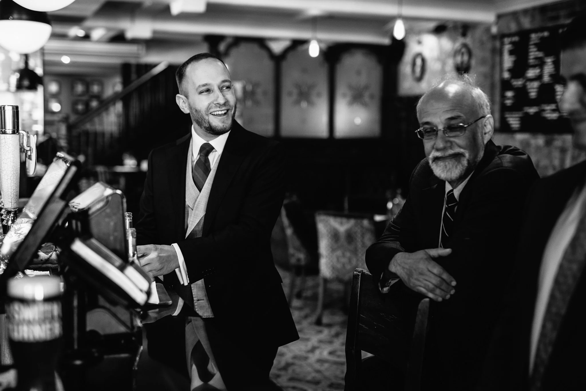  Groom smiling as he orders a drink in the George pub Chiswick 