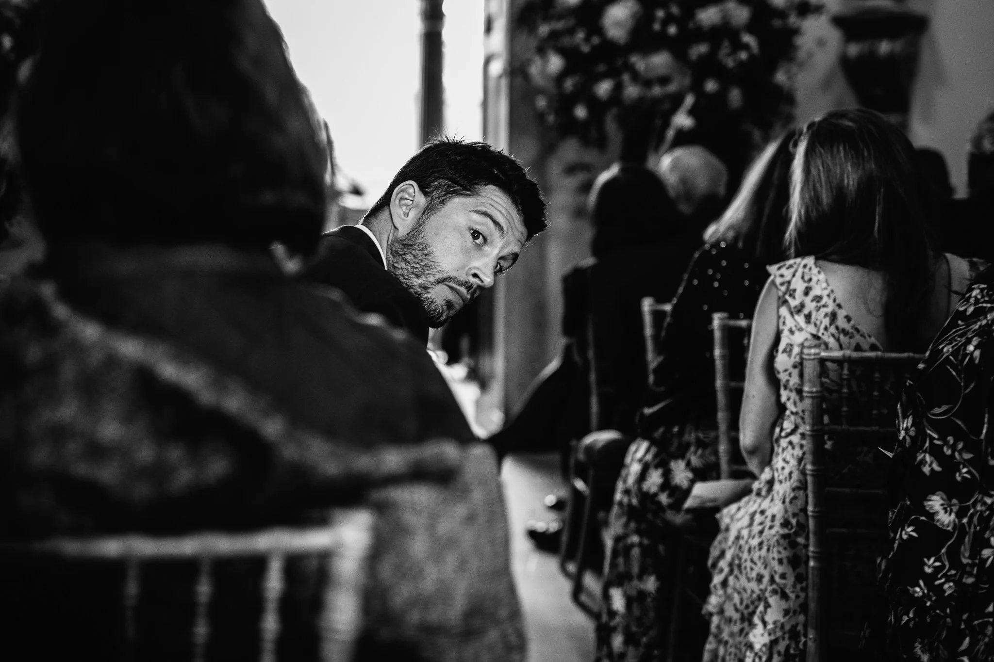  Wedding guest looks down the aisle to see if the bride has arrived yet 