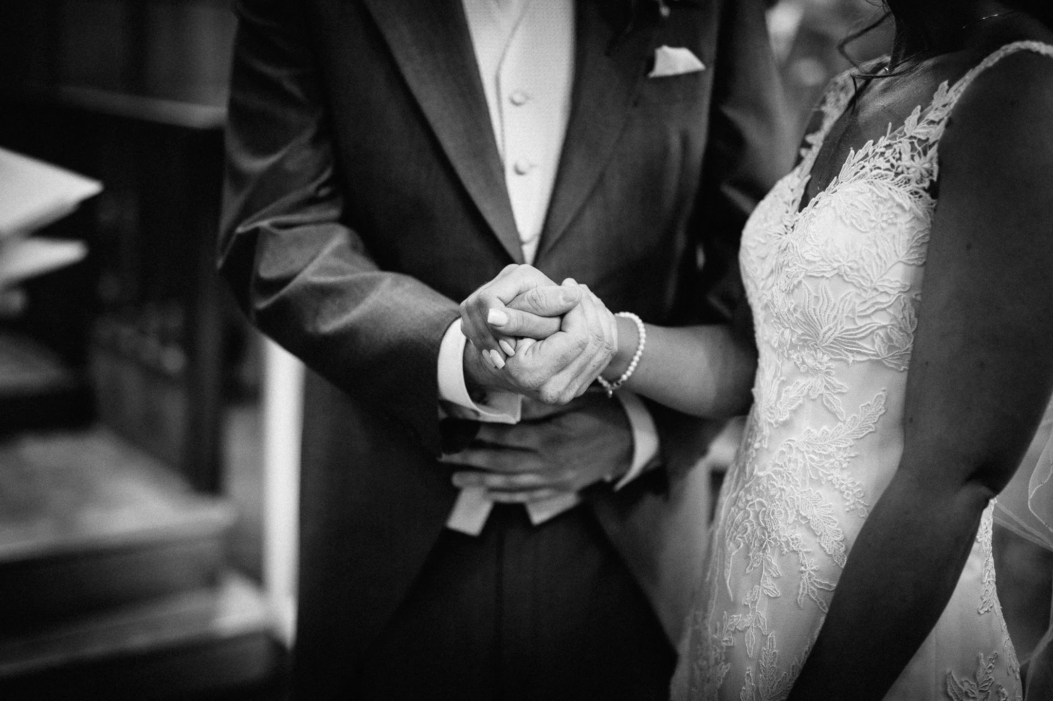  Bride and Groom holding hands on their wedding day  at the Chapel of St Luke at Epsom College 
