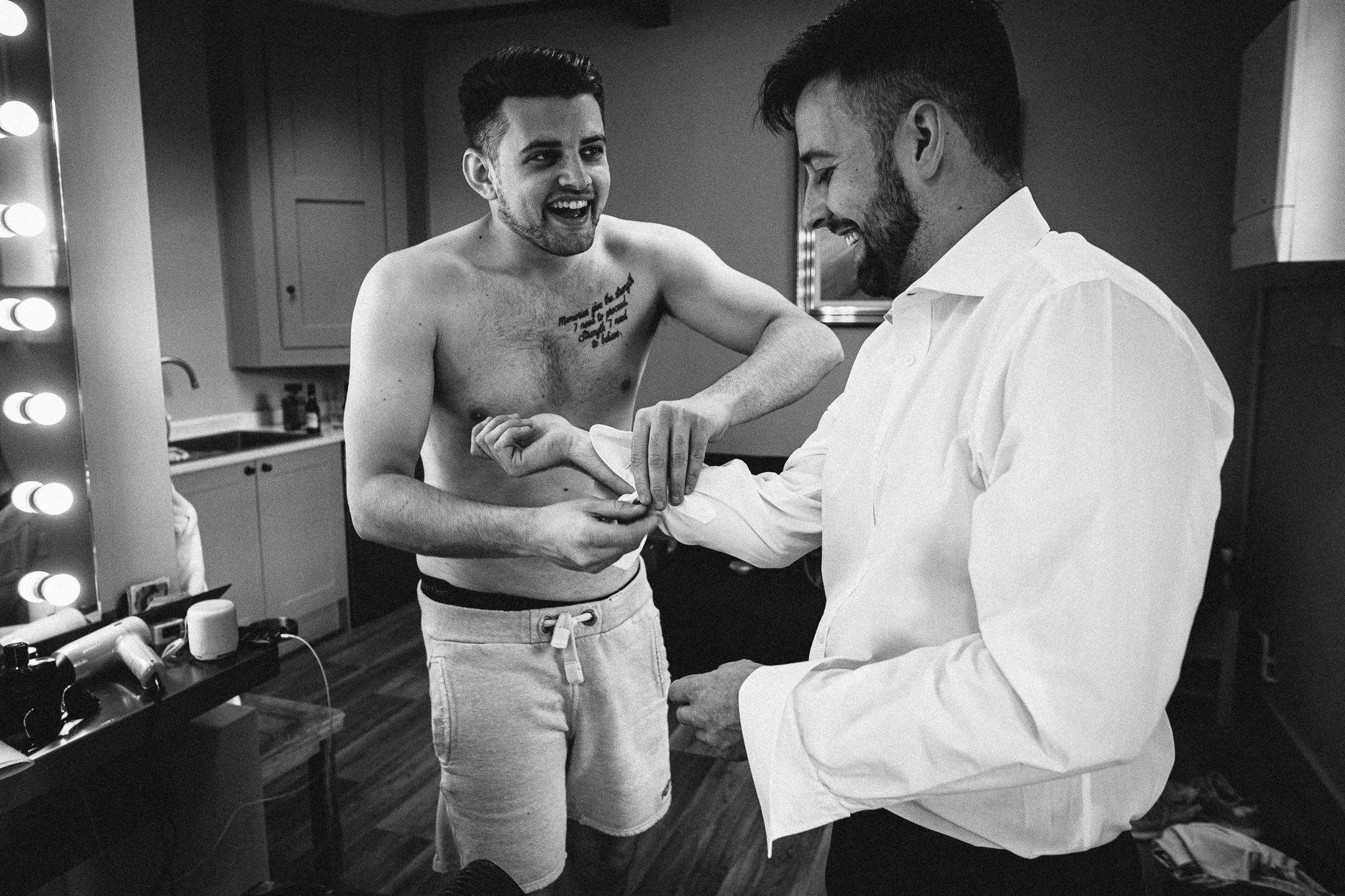  Topless groomsman helps the Groom with his cufflinks 