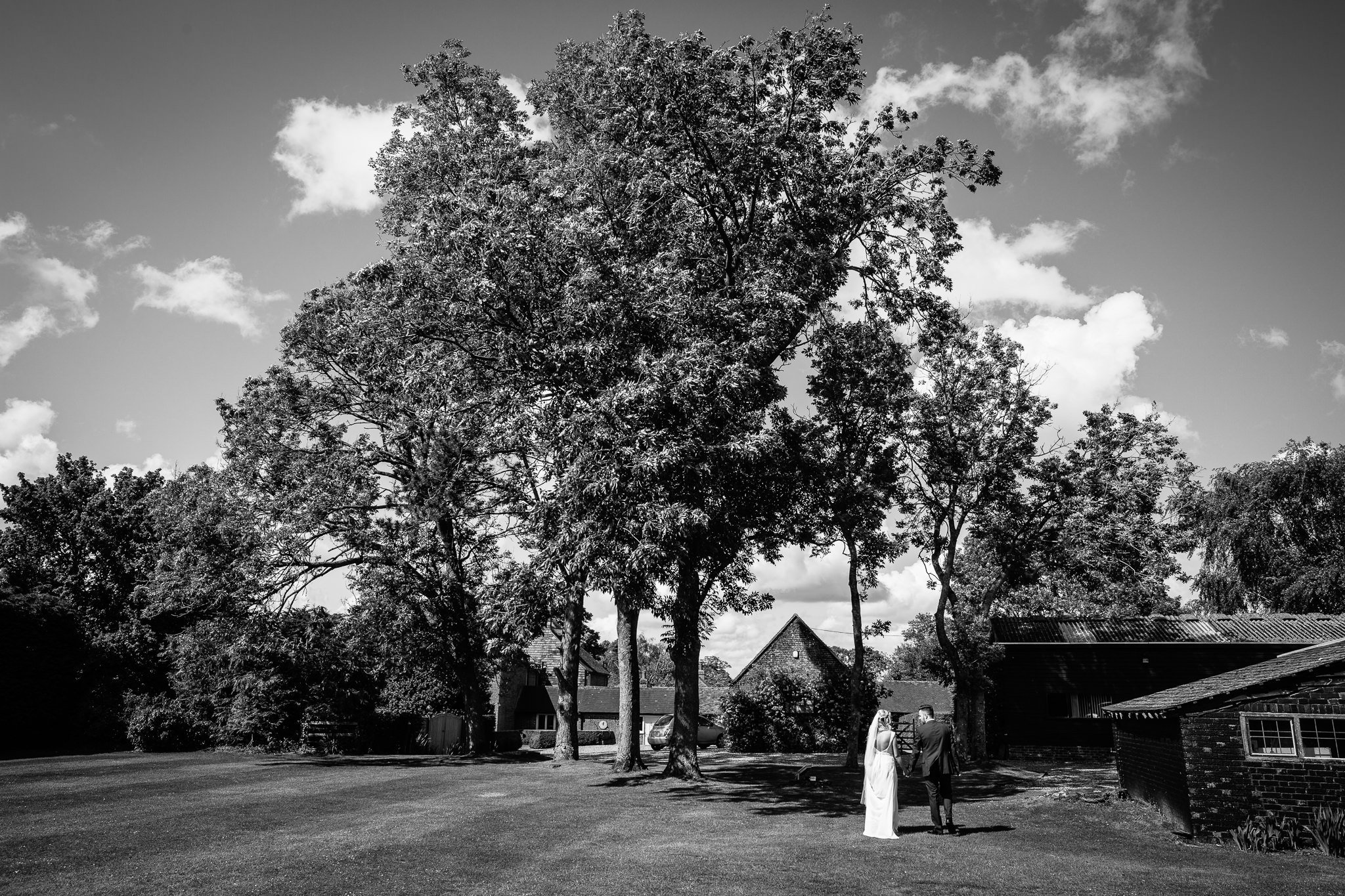  Bride and groom walk hand in hand around the grounds of Winters Barns Wedding Venue Kent 