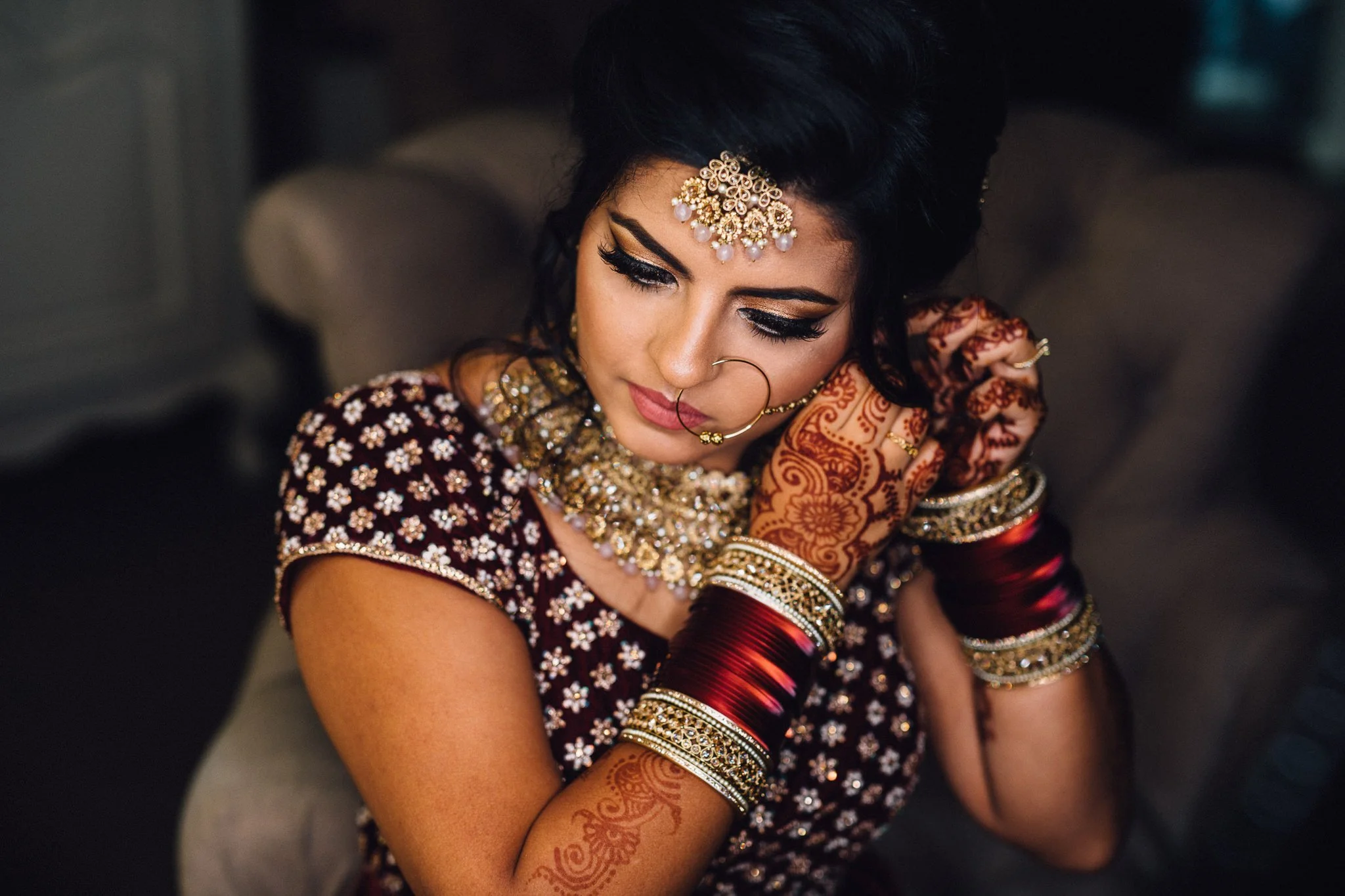  Bride puts on her earring at Trunkwell House in Berkshire 