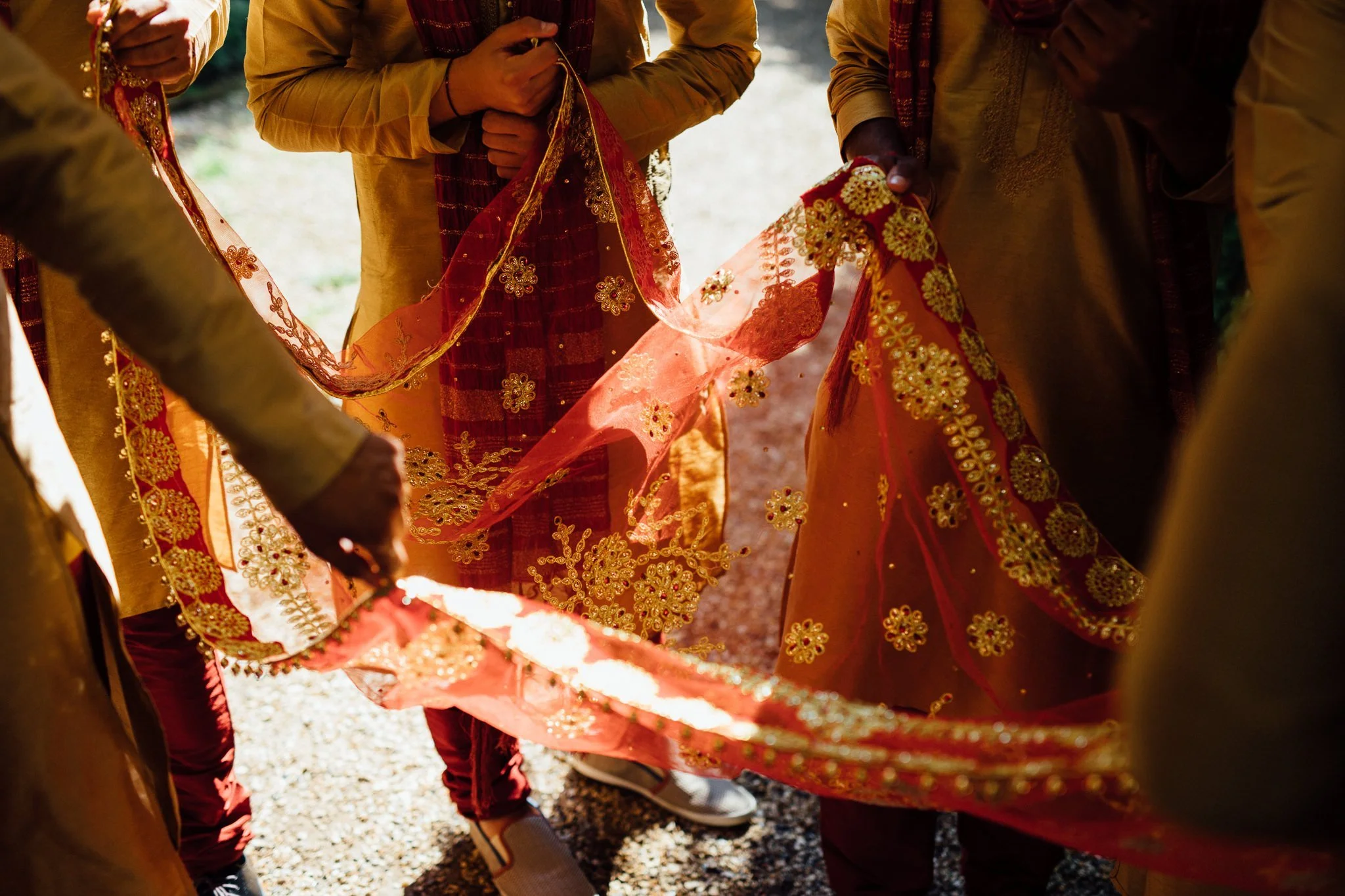  Men hold a piece of fabric to hold over the bride 