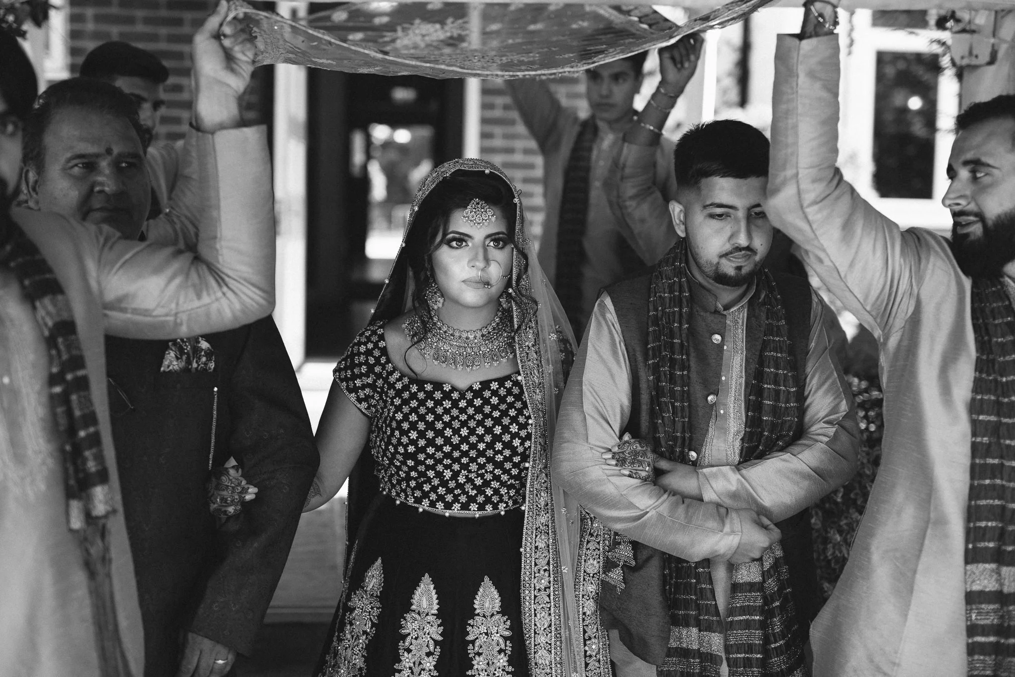  Groomsmen hold up a piece of fabric over the bride 