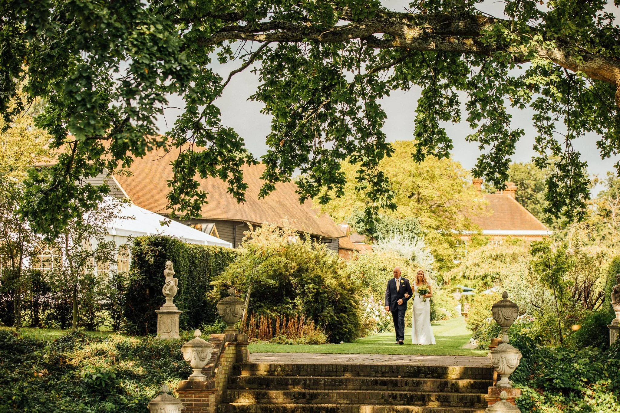  Bride walks down the aisle at Micklefield Hall with her father 