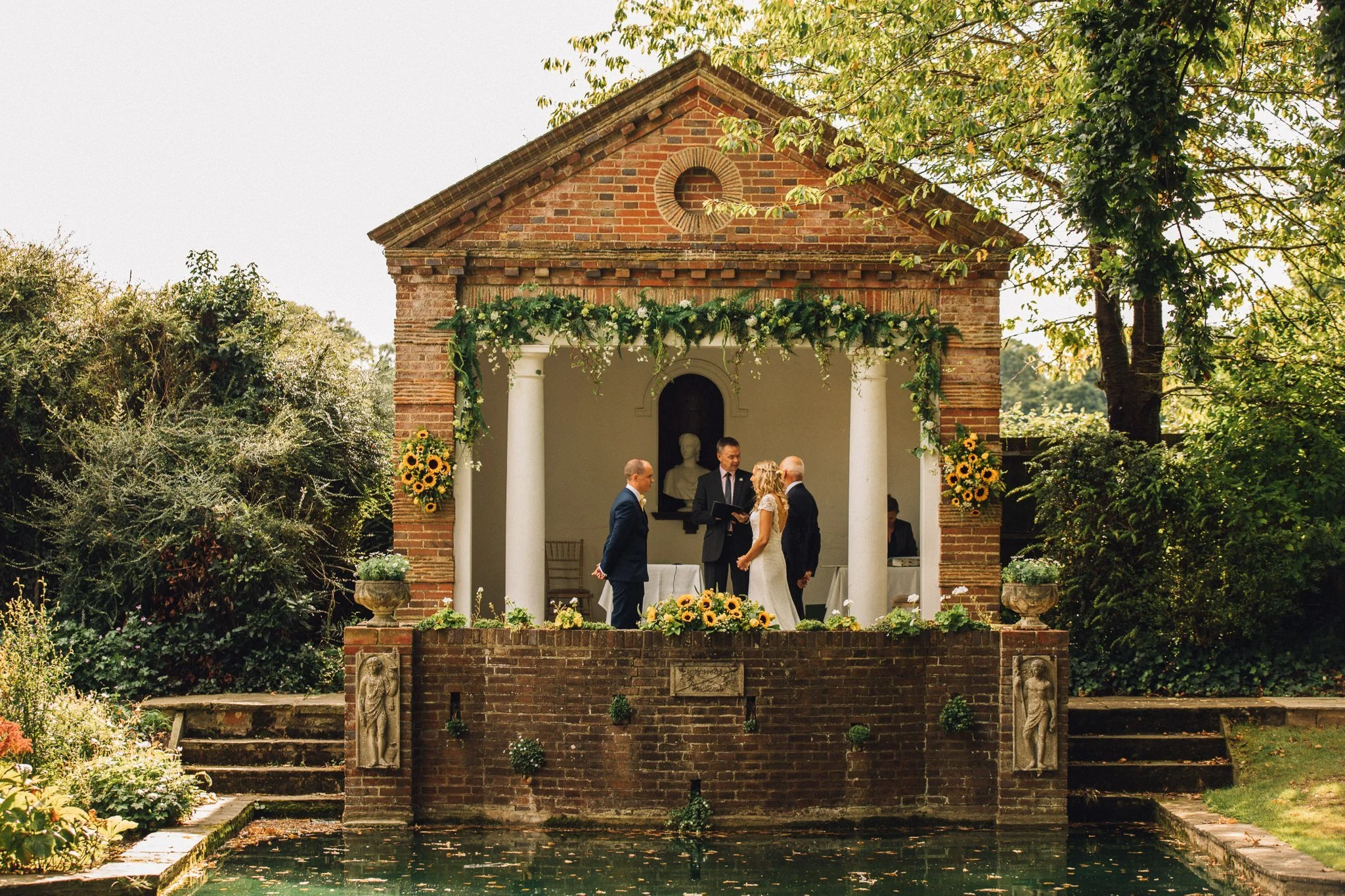  Bride and Groom stand in front of the temple at Micklefield Hall 