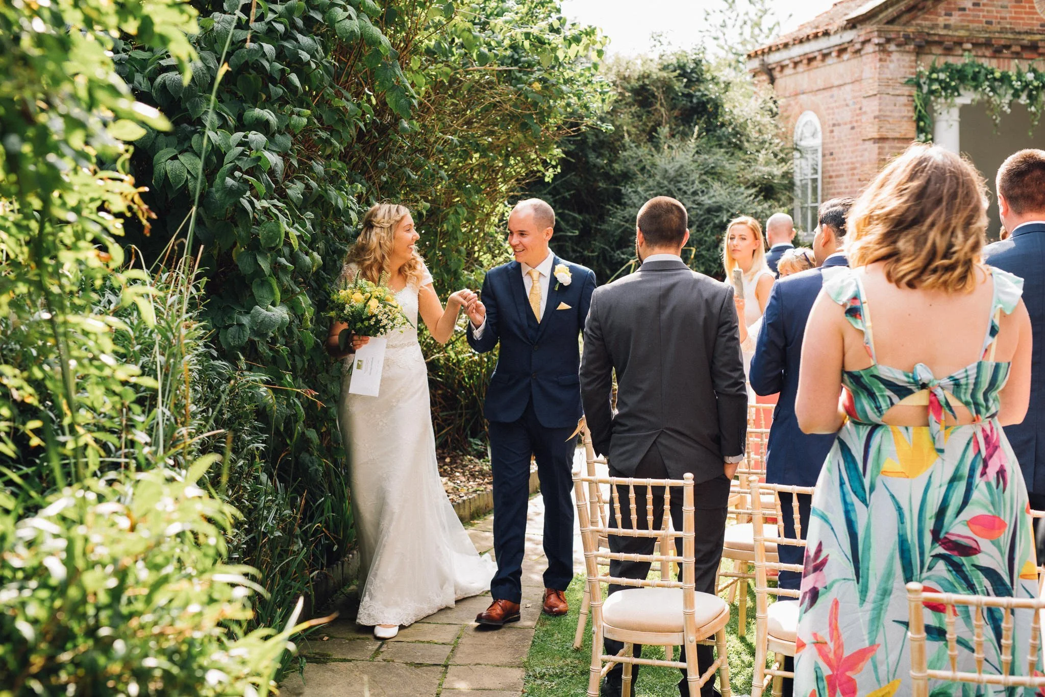  Bride and Groom walk away from the temple after being married at Micklefield Hall 