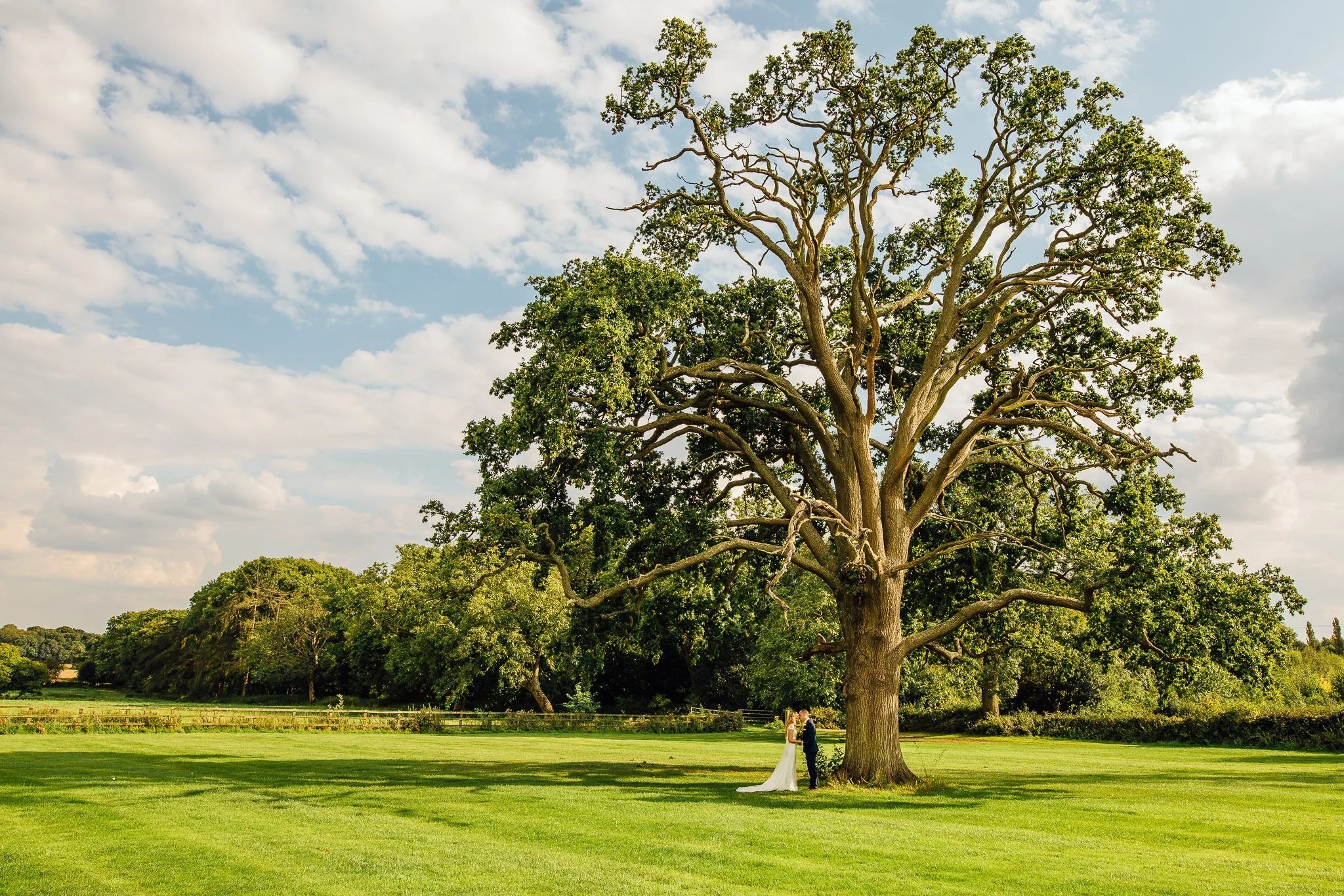  Bride and Groom kissing under a tree at Micklefield Hall 