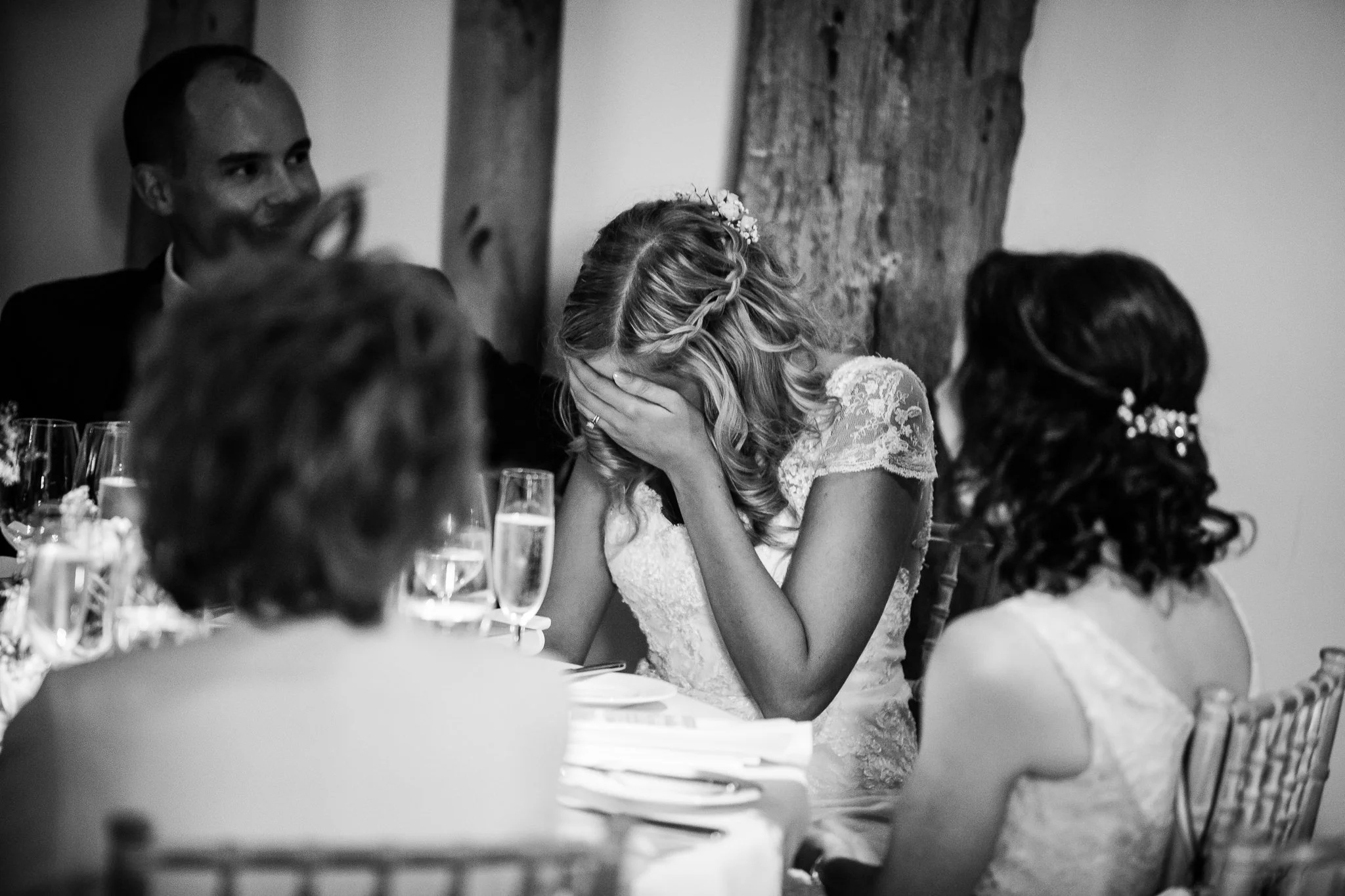 Bride covers her face in embarrassment during the wedding speeches 