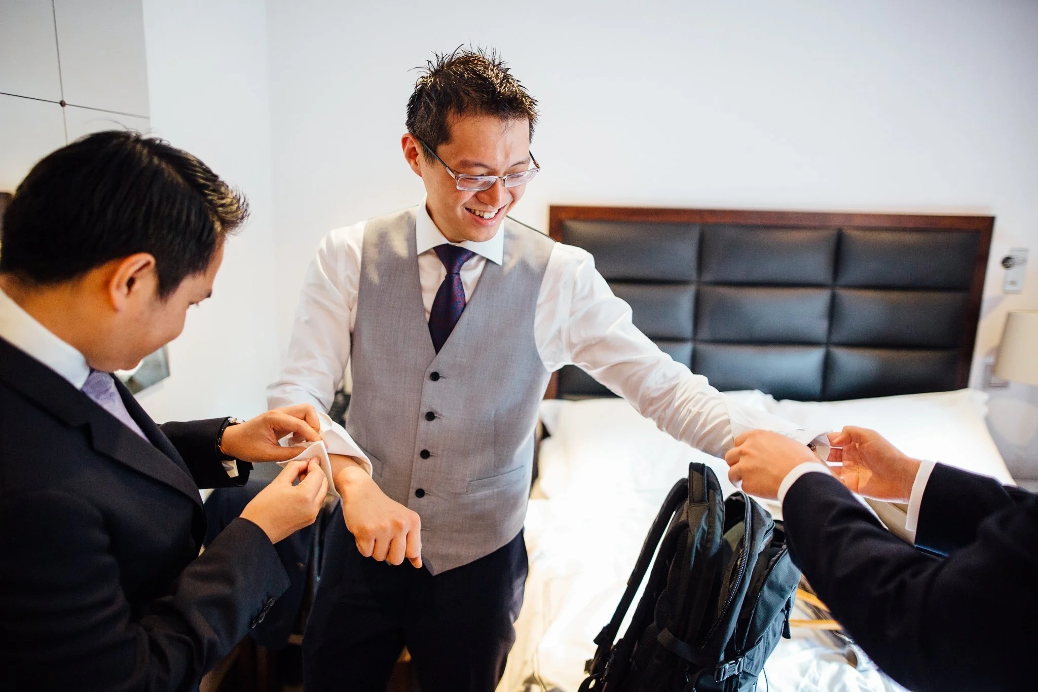  Groom has cufflinks inserted by groomsmen 