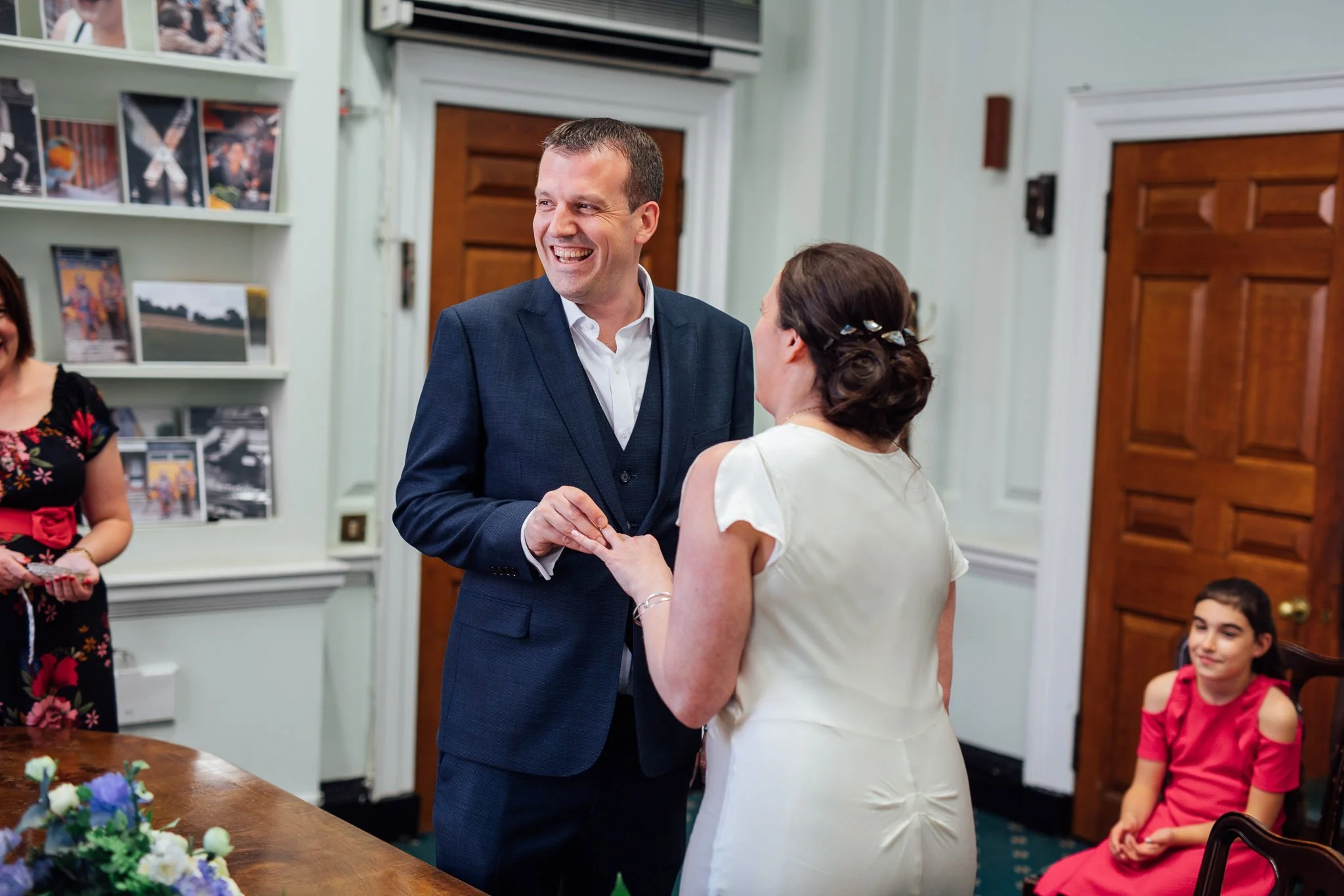  The groom places the ring on the bride’s finger at Camden Town Hall 