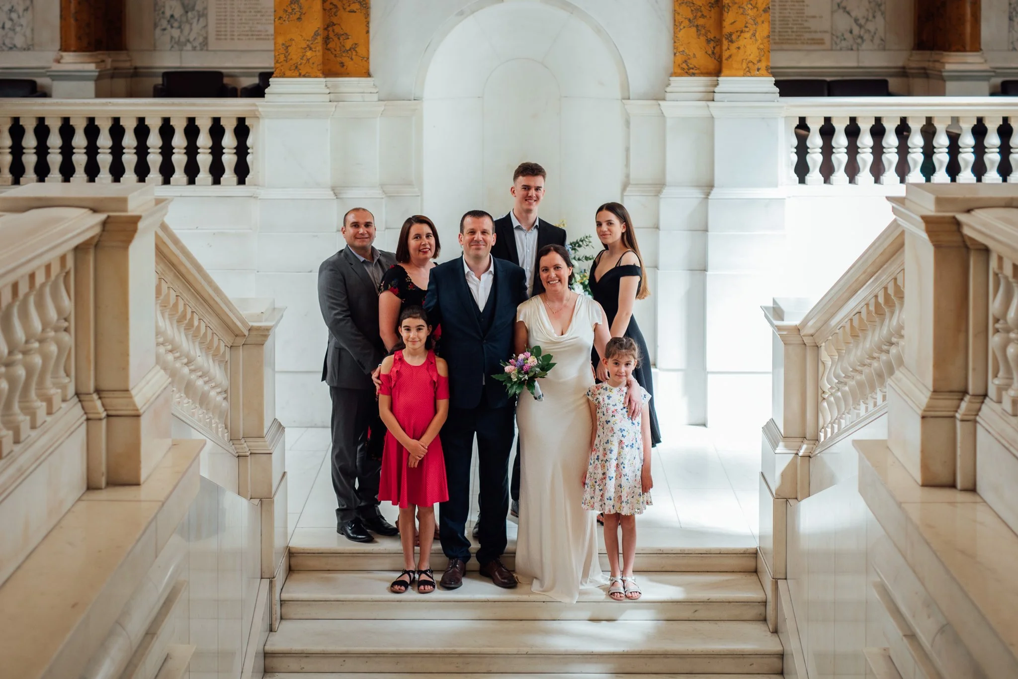  Group photo of all the wedding guests on the stairs at Camden Town Hall 