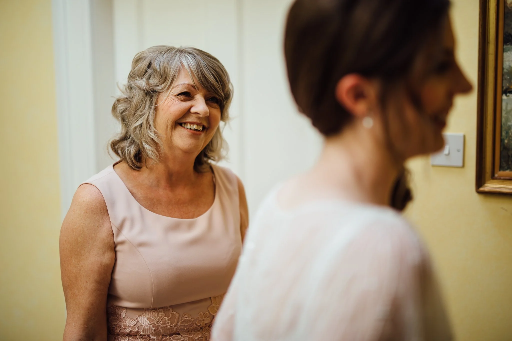  Mother of the Bride looks at the Bride with a smile on her face 