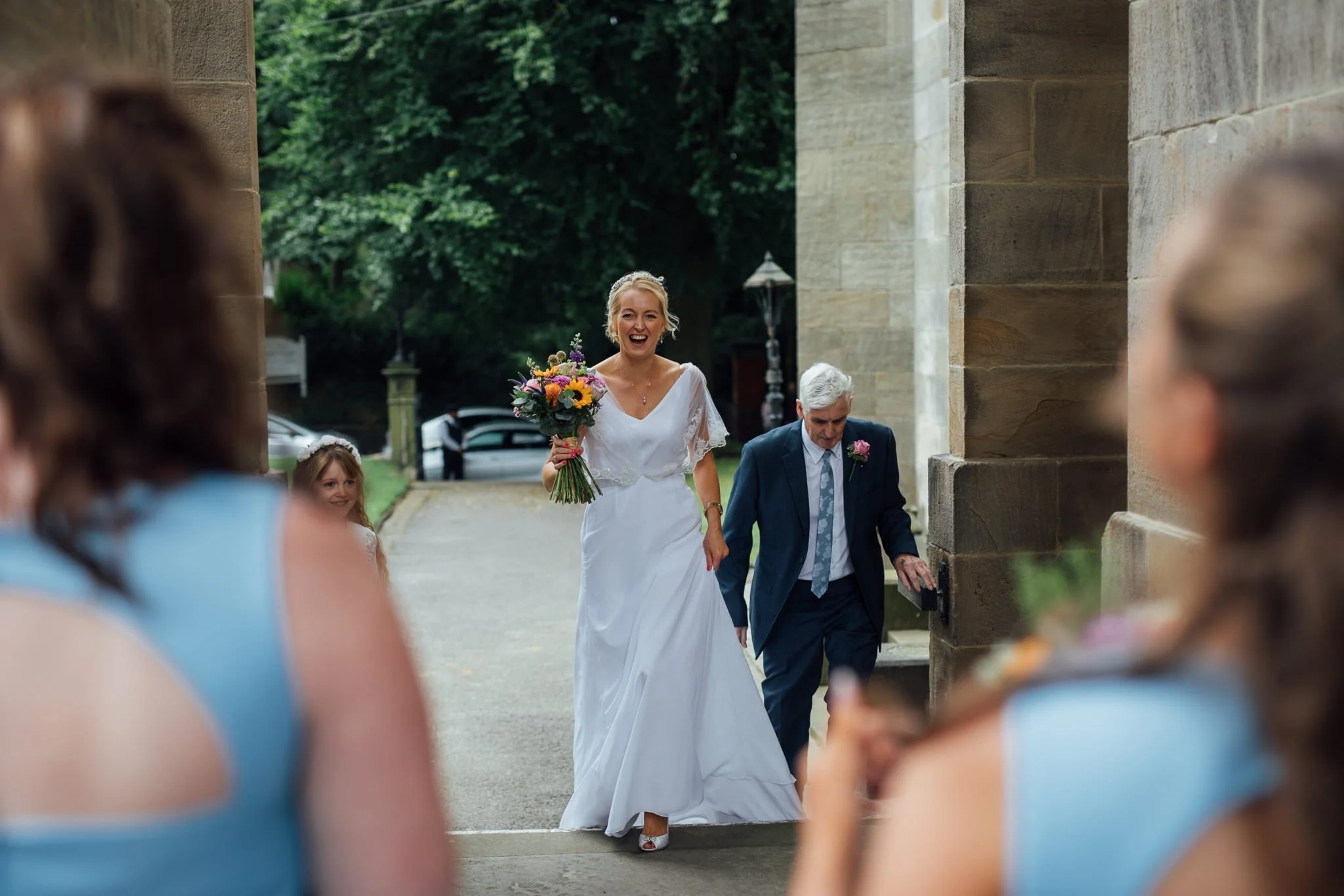  Bride overjoyed to see her Bridesmaids outside All Saints Stand Church Whitefield 