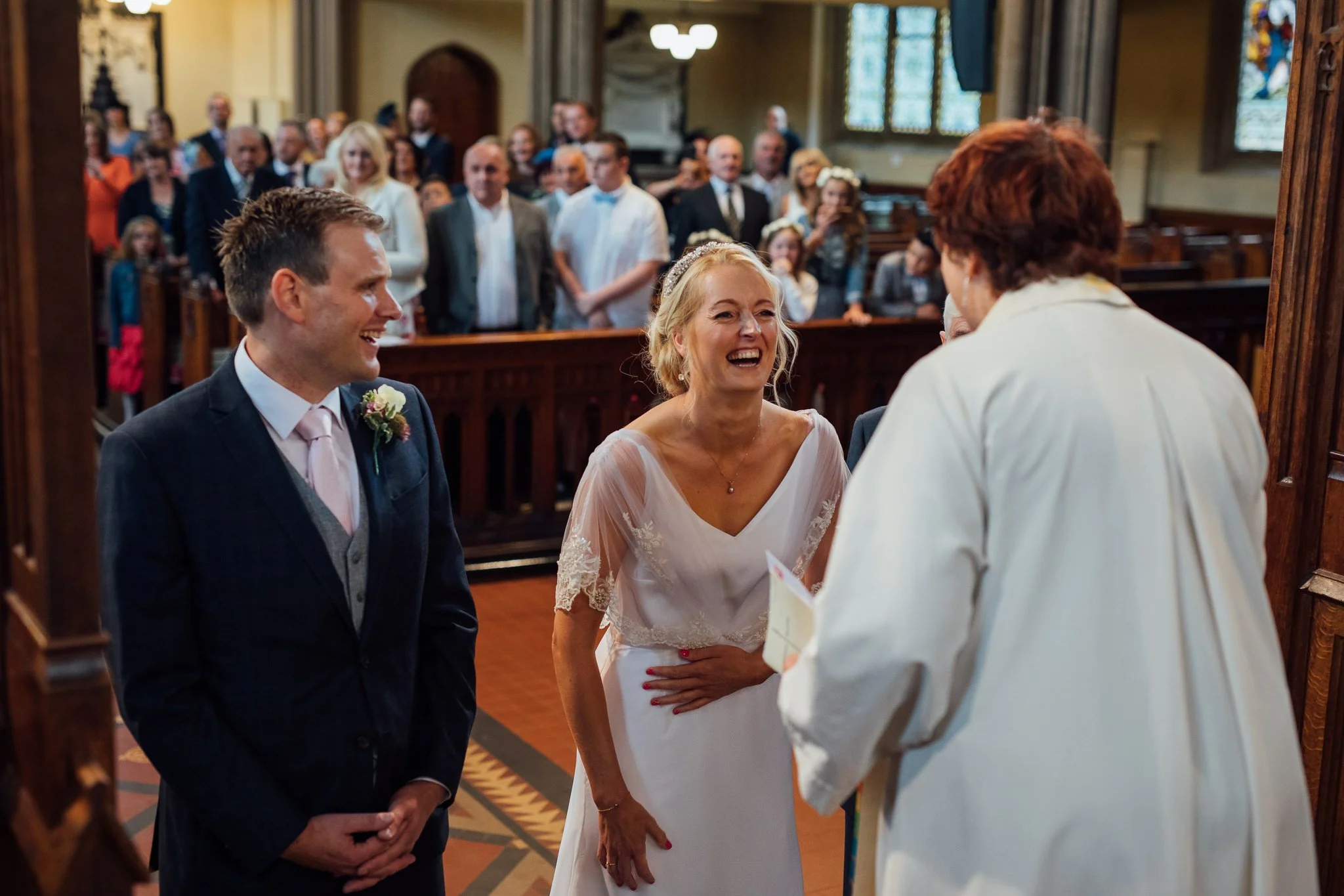  Bride laughing with the Vicar at All Saints Stand Church Whitefield 