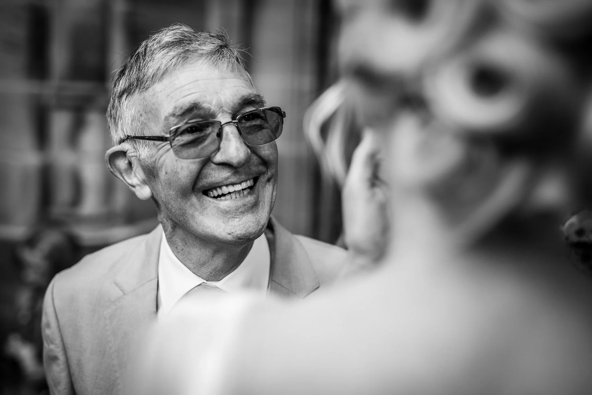  Male wedding guest smiles at the Bride 