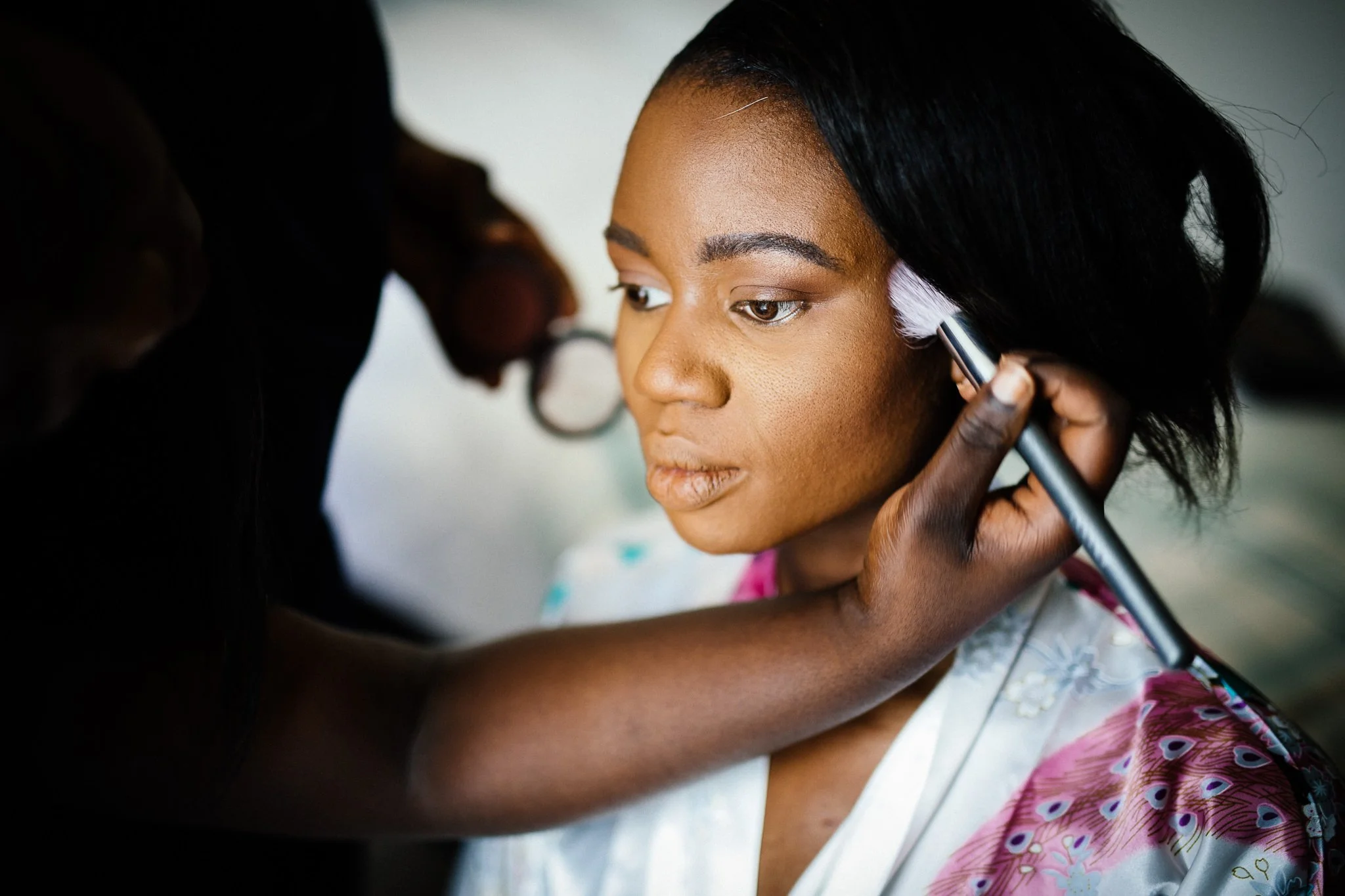  Bride has makeup applied before her wedding at Newland Hall Essex 