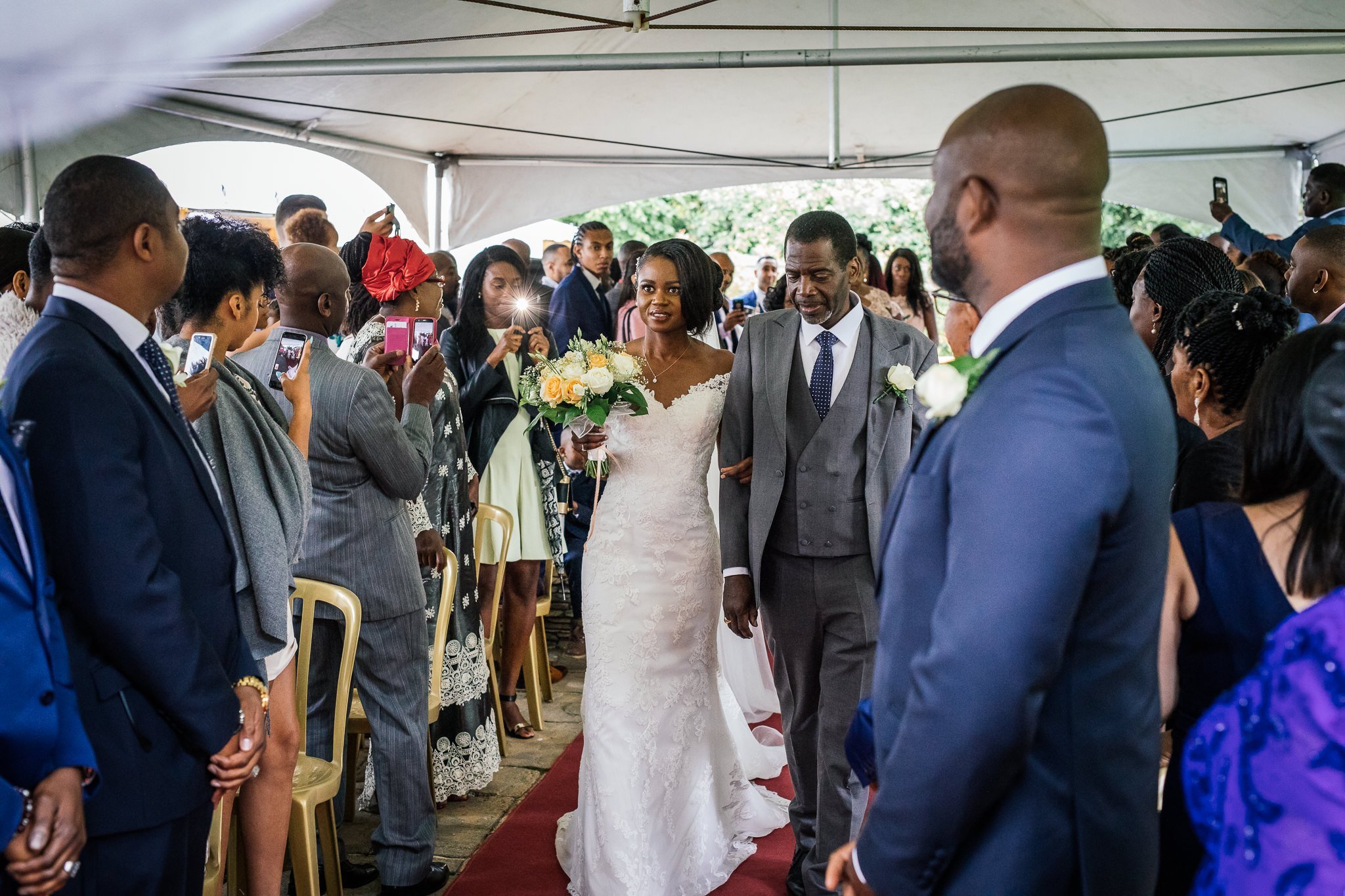  Bride walking down the aisle at Newland Hall Essex 