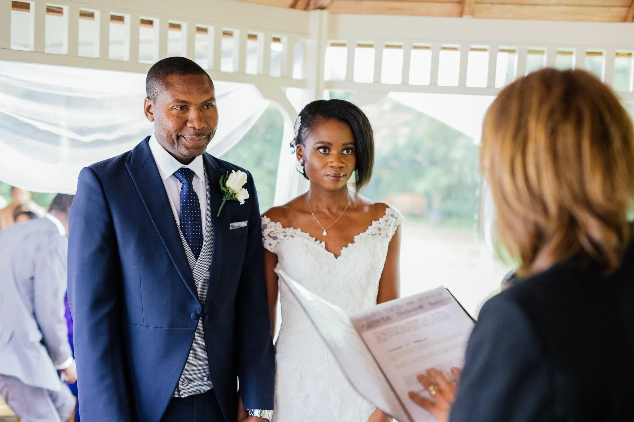  Bride and groom standing in front of the registrar at Newland Hall Essex 