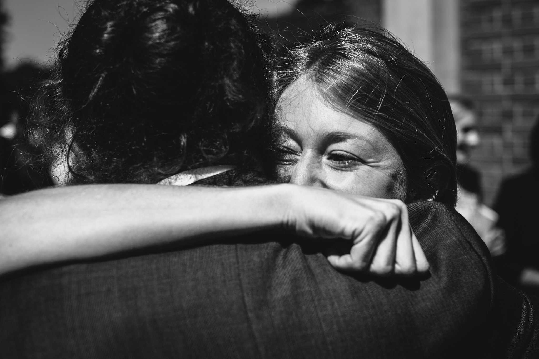  Female wedding guest hugs the groom 