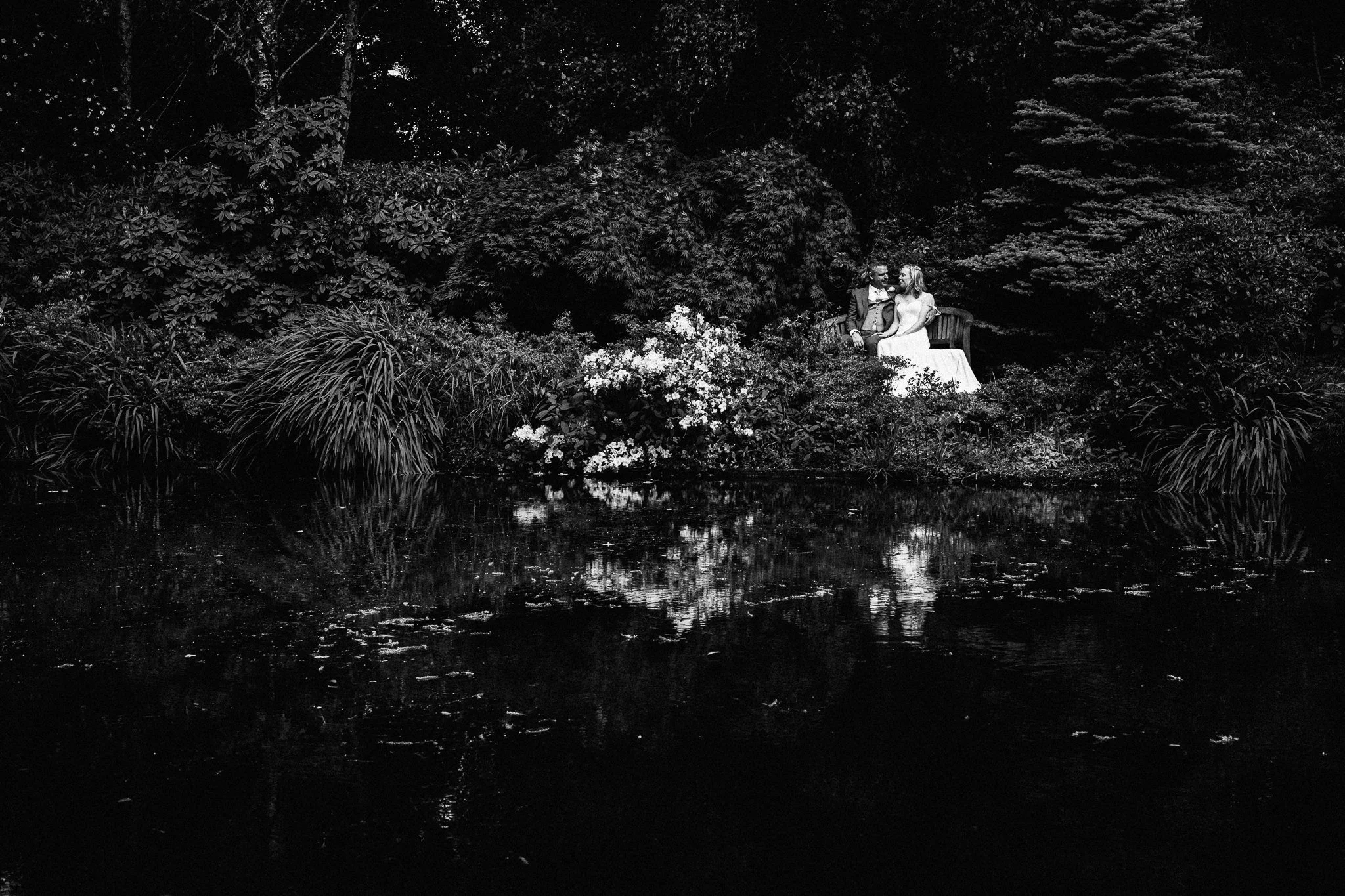  Bride and Groom sitting next to the lake at Rivervale Barn 