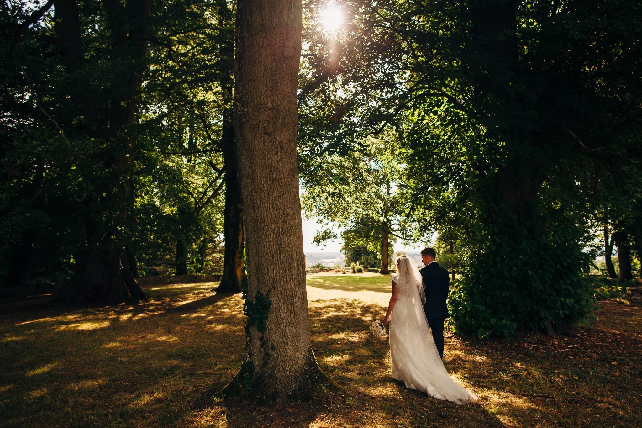  Bride groom walk through a wooded area of Aynhoe Park 