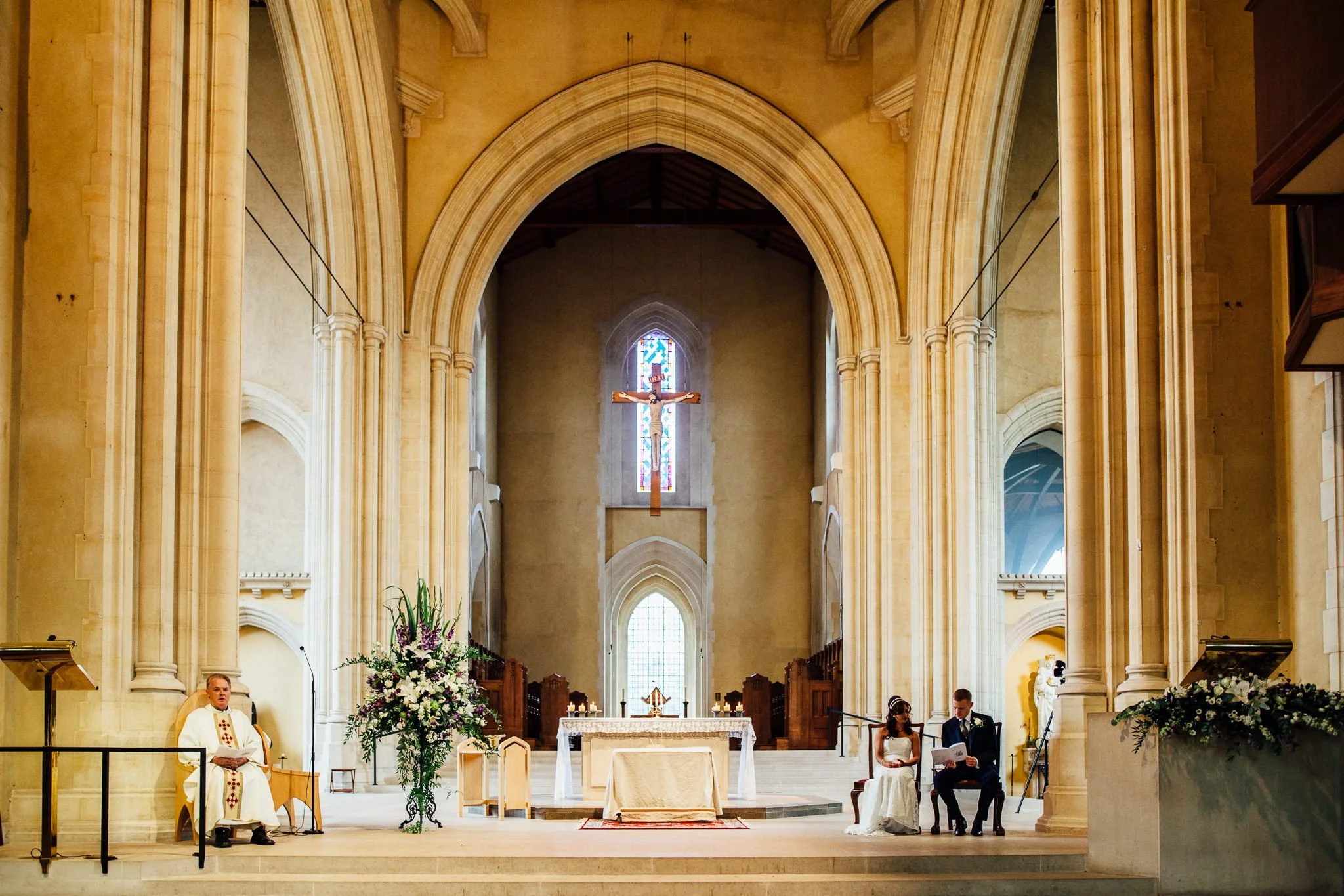  Bride and Groom sitting down during the wedding ceremony at Ealing Abbey 