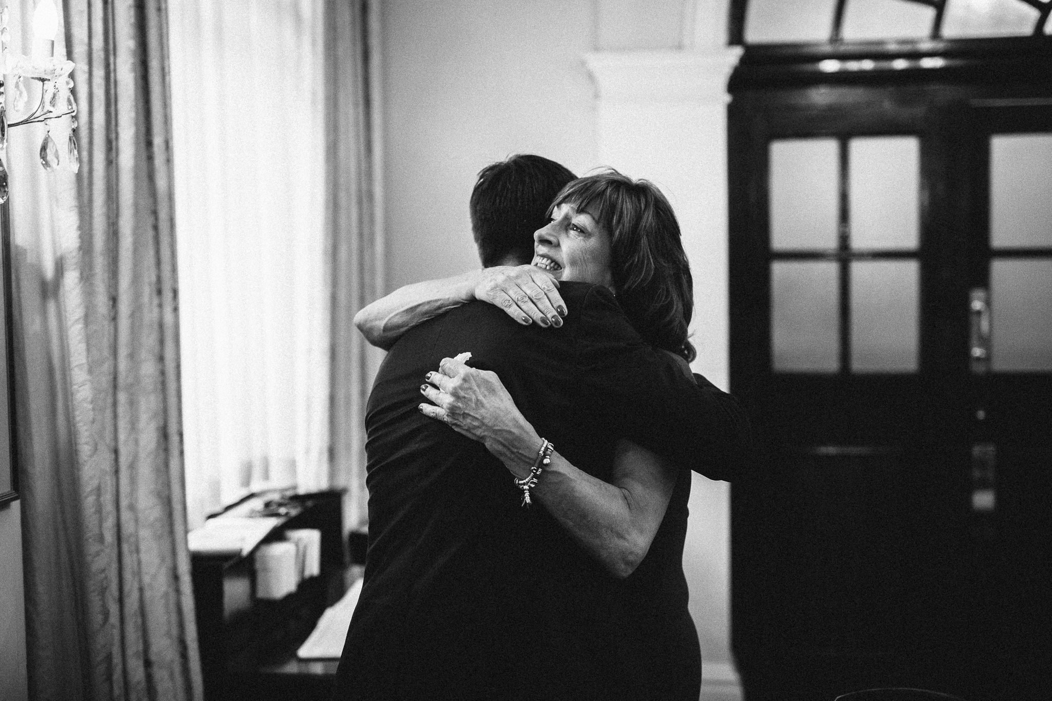  Mother of the groom hugs the groom after the ceremony at Chelsea Old Town Hall 