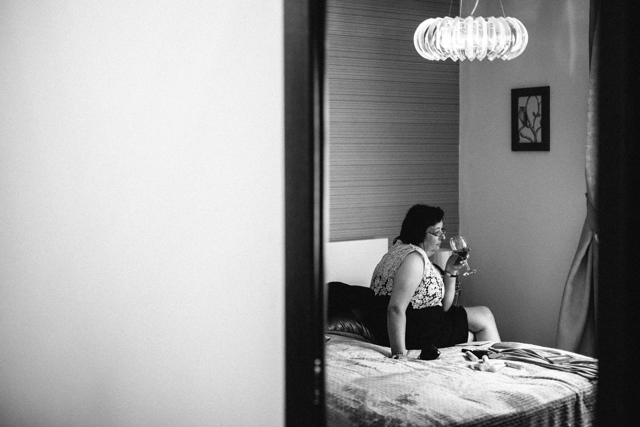  Mother of the bride drinking a glass of wine seen in the reflection of a mirror 